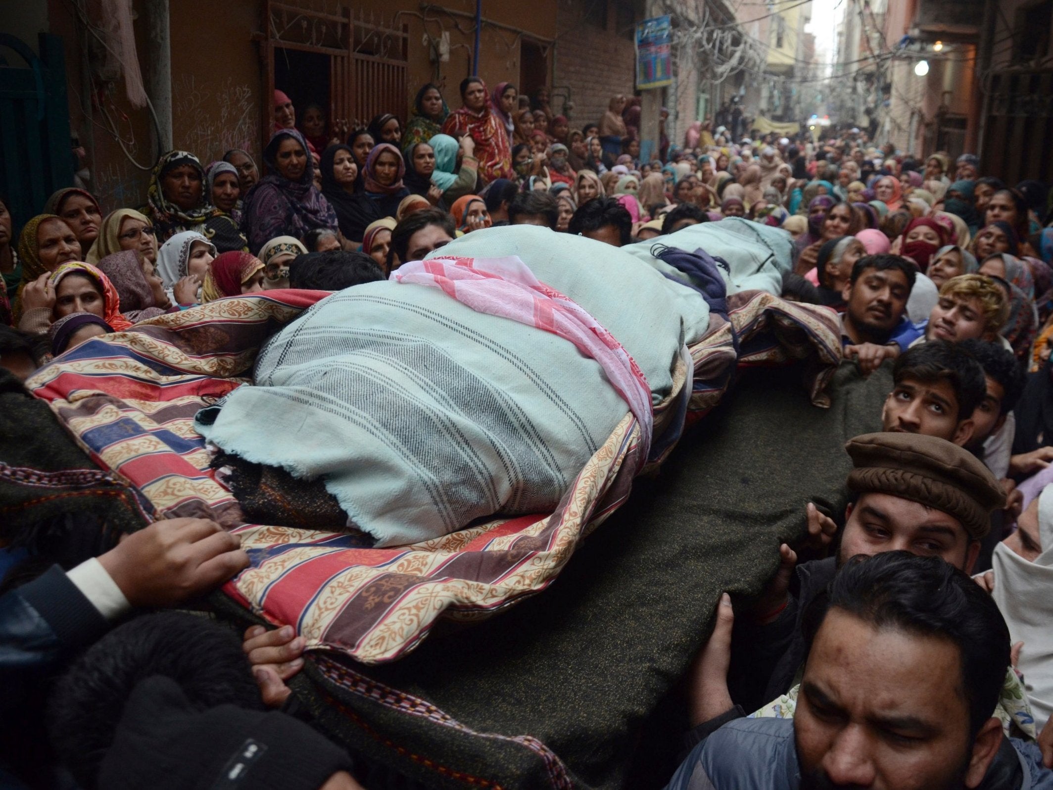 People carry a body of one of the members of a family, who were killed by counter-terrorism officers