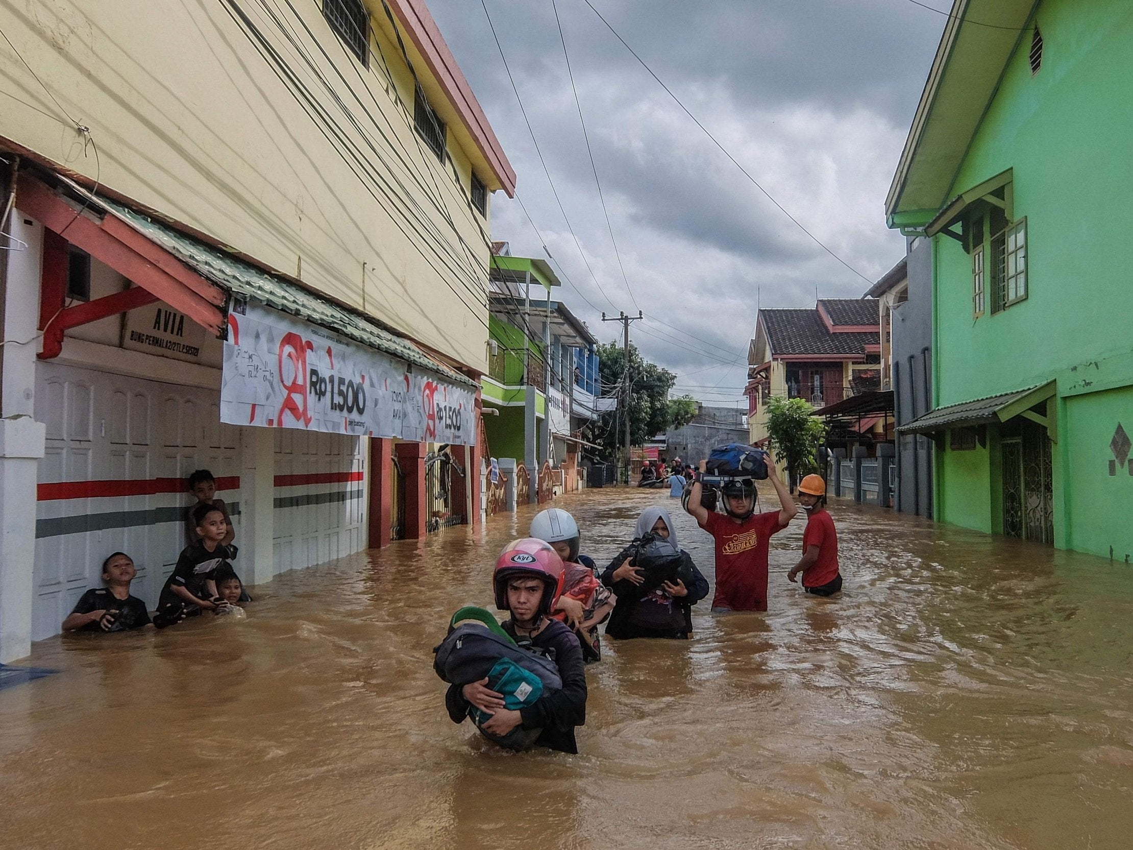 Residents evacuate their homes in Makassar, Indonesia, as heavy rain and strong winds cause flash flooding.