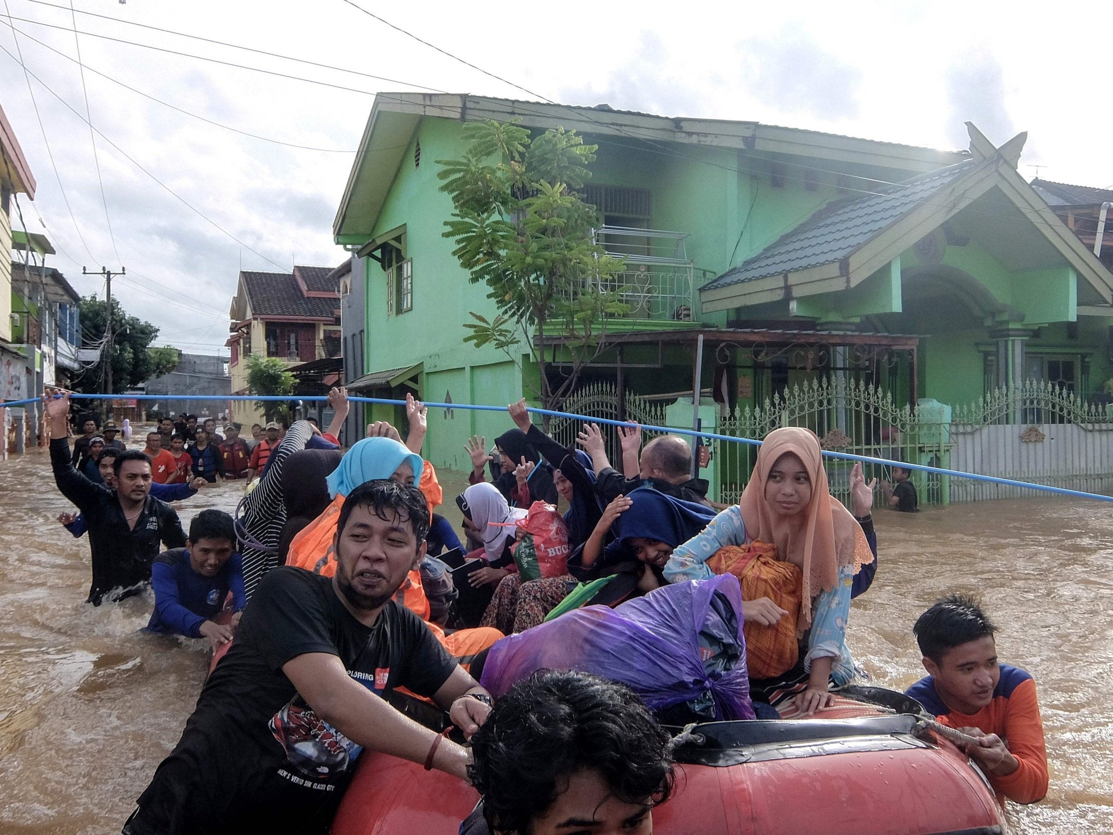 Residents evacuate their homes in Makassar, Indonesia, after heavy rain and strong winds pounded the southern part of Sulawesi island, swelling rivers that burst their banks.