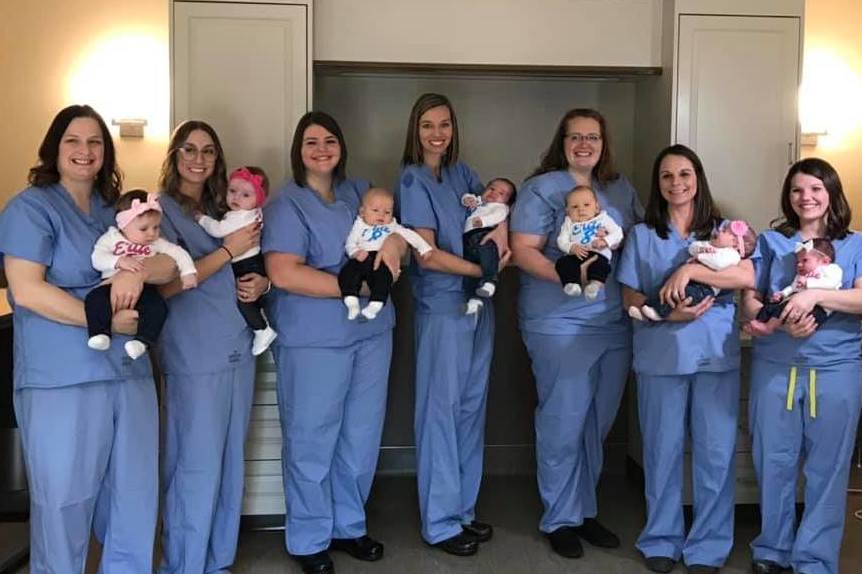 The mothers pose for a photograph with their babies.