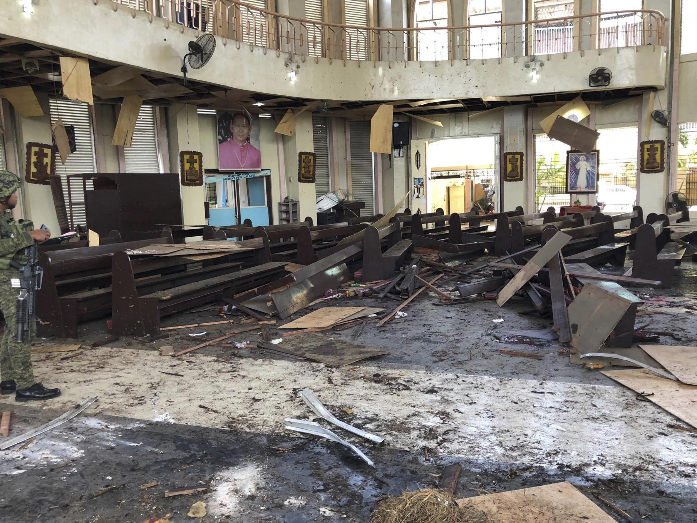 A soldier views the site inside a destroyed Roman Catholic cathedral in Jolo