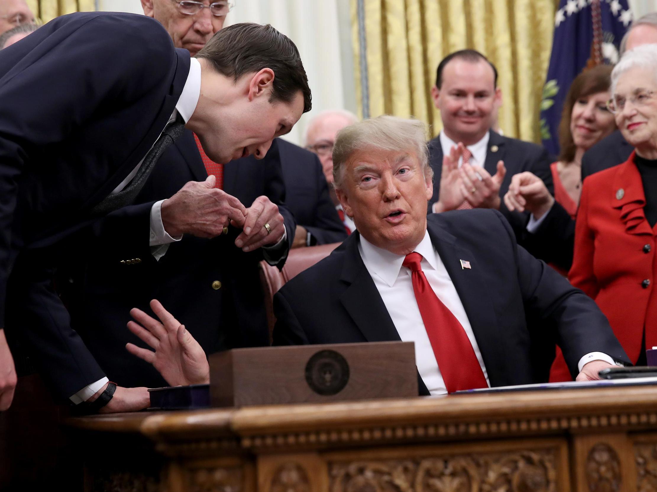 Pictured: Senior adviser to the President Jared Kushner (L) leans in to speak with US President Donald Trump during the signing ceremony for the First Step Act and the Juvenile Justice Reform Act in the Oval Office of the White House 21 December 2018 in Washington, DC.