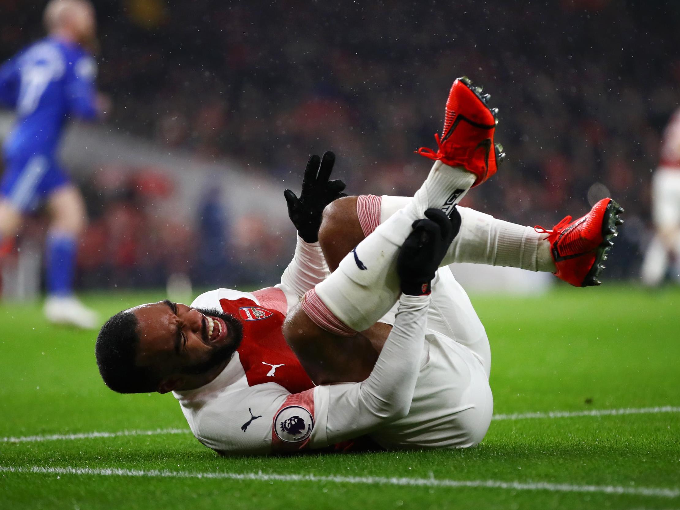 Alexandre Lacazette reacts after taking a knock during the first half