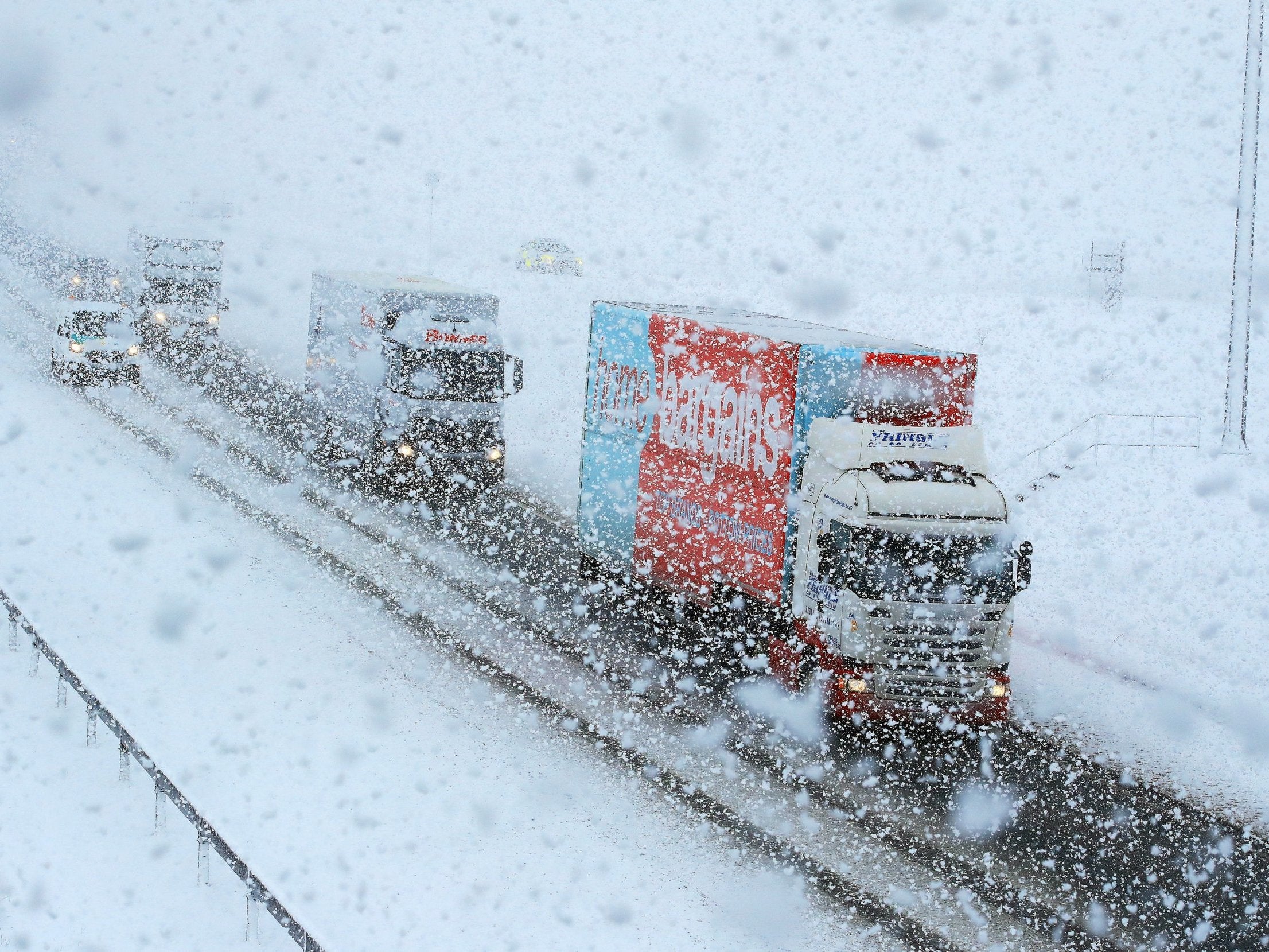 Lorries navigate through the snow on the A6 near the village of Shap, in Cumbria (PA)