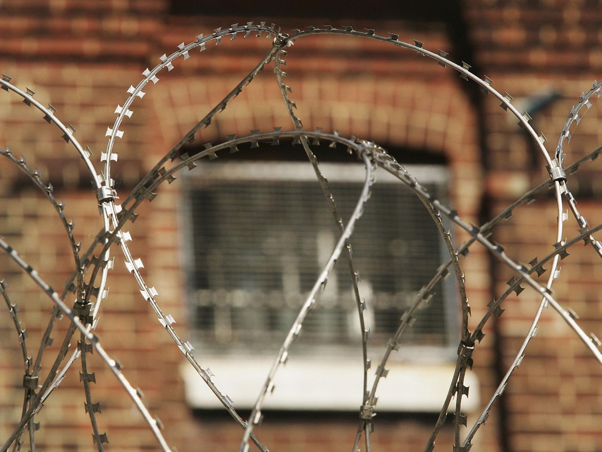 The window of a cell at Norwich Prison is seen through coils of razor wire