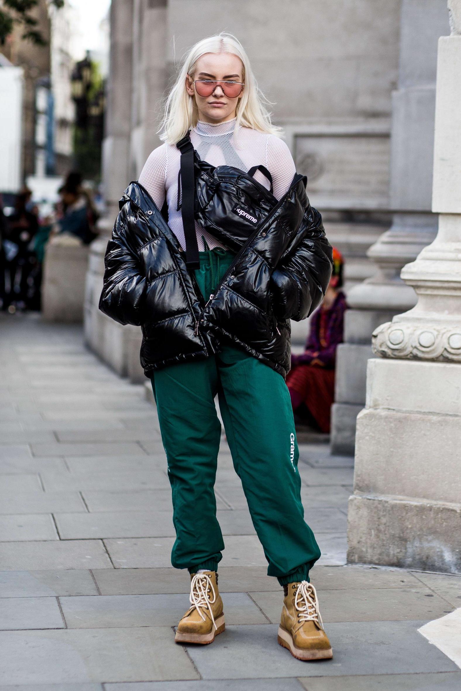 Hiking boots are becoming increasingly popular on the street style scene, with this London Fashion Week attendee pairing hers with a vinyl down jacket and green tracksuit bottoms (Rex)