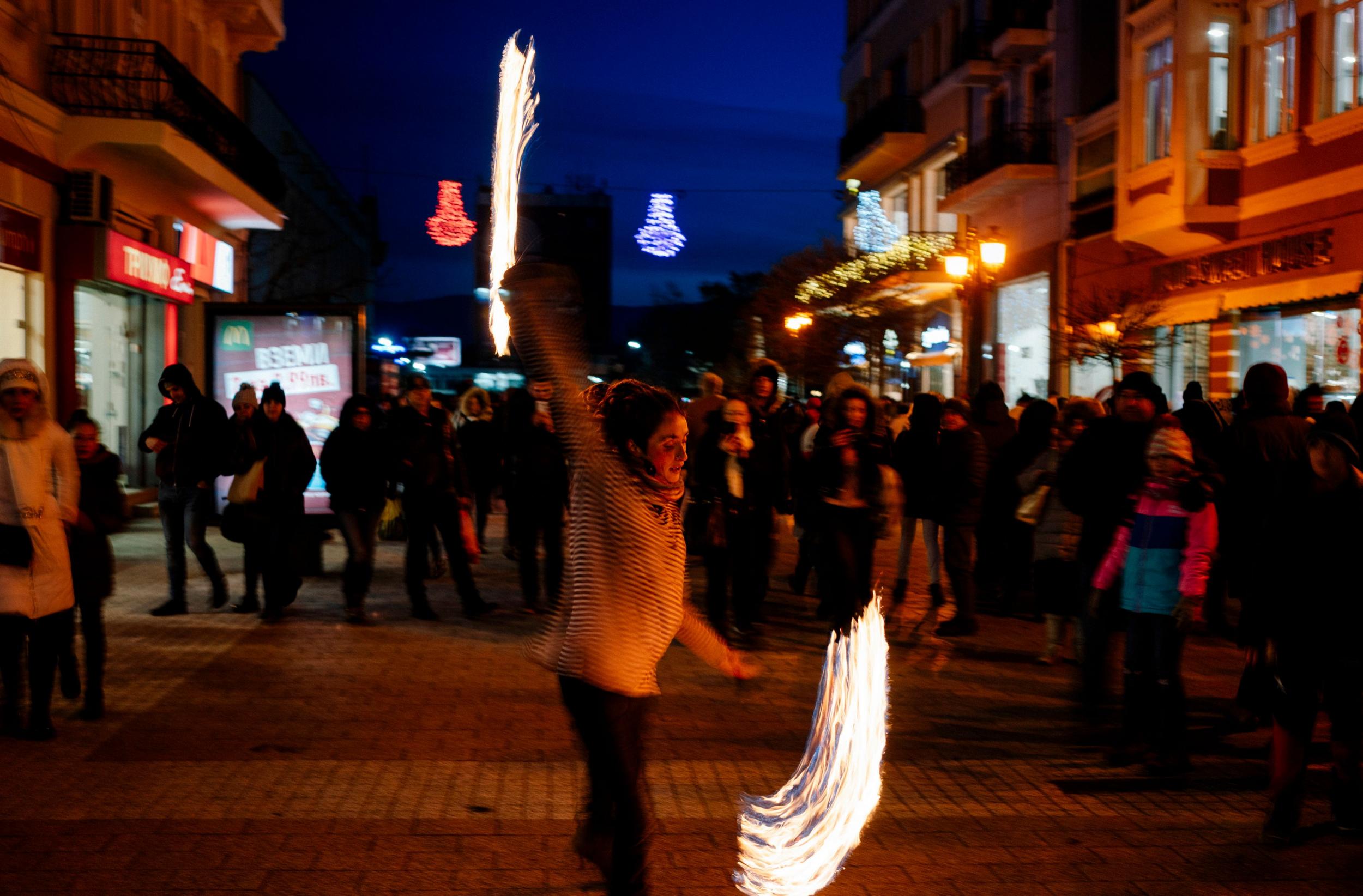 A street artist performs on 12 January, the night of the European capital of culture opening ceremony (AFP)