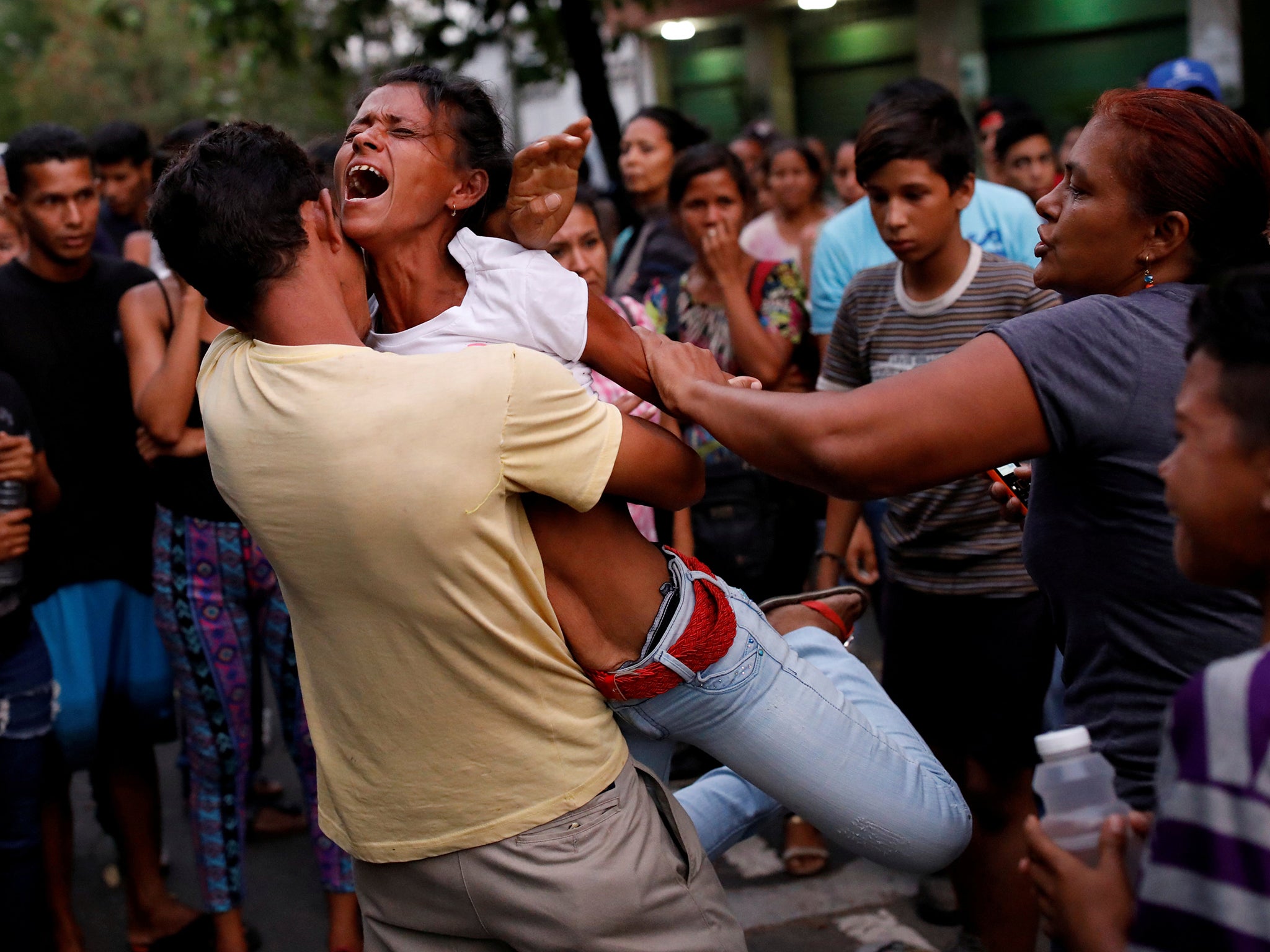 Relatives of inmates held at the Carabobo Police station, where a fire broke out, wait outside (Reuters)