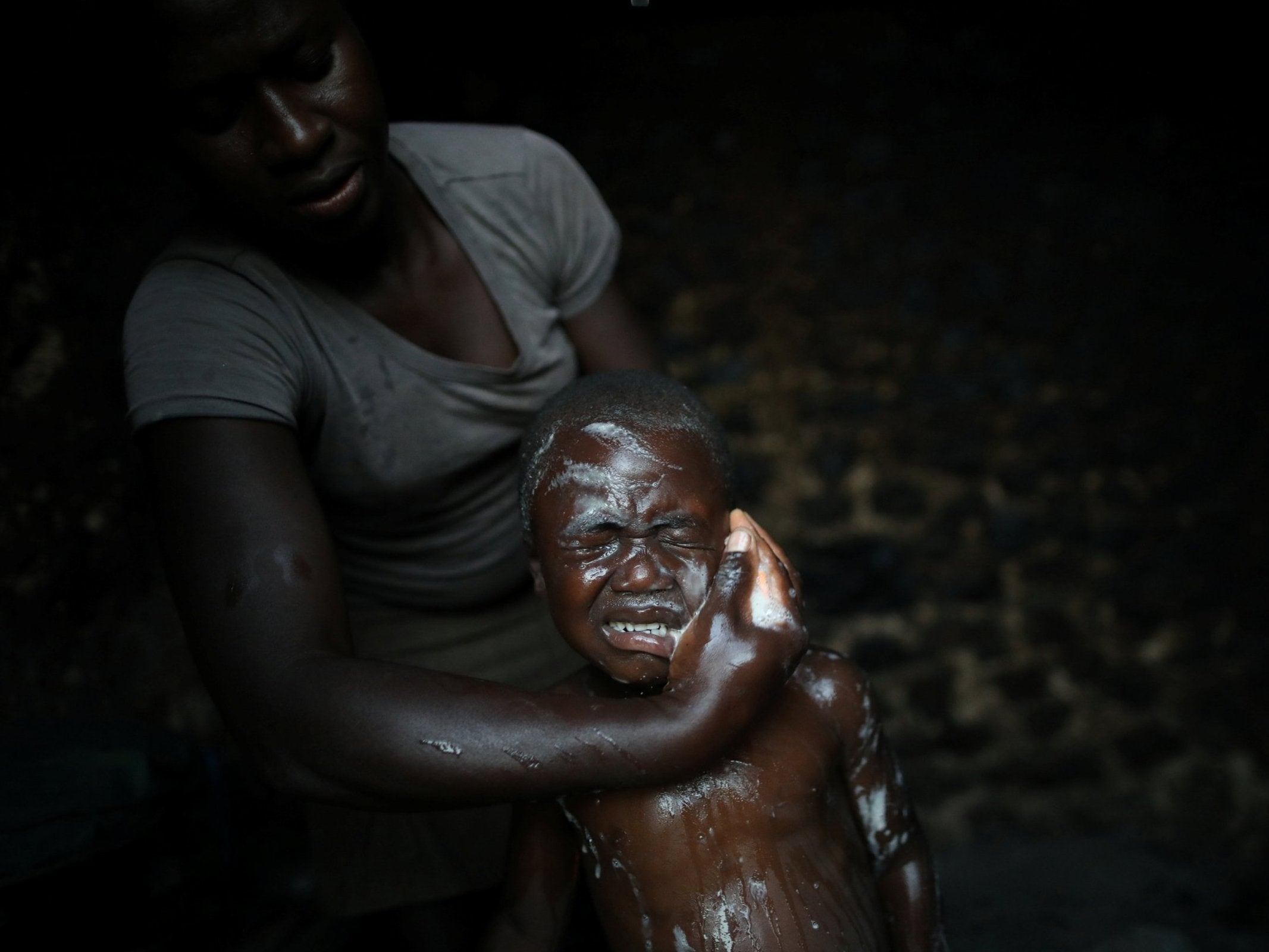 A man bathes his son at the family home