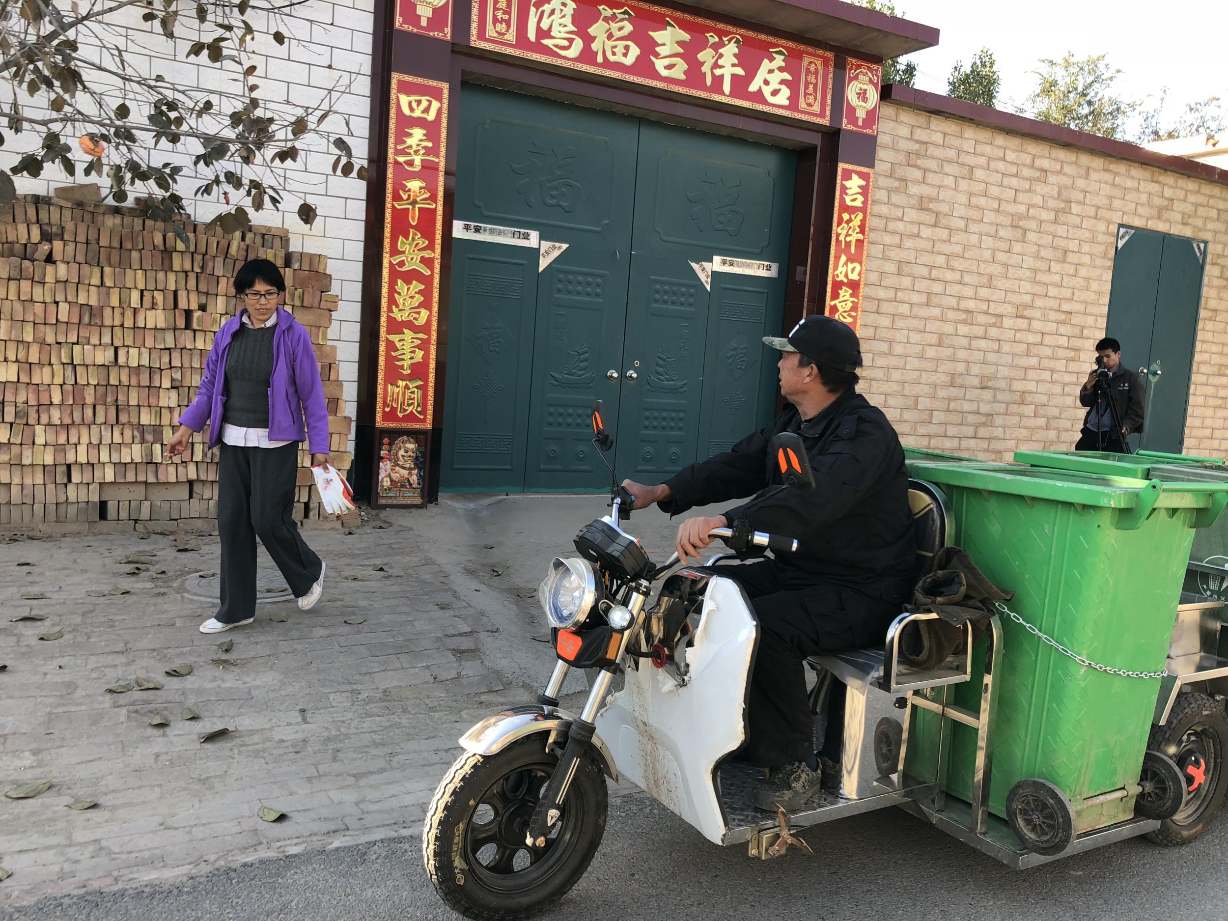 A local man drives a specially converted rubbish collection tricycle through Xicai village telling locals to bring out their recycling