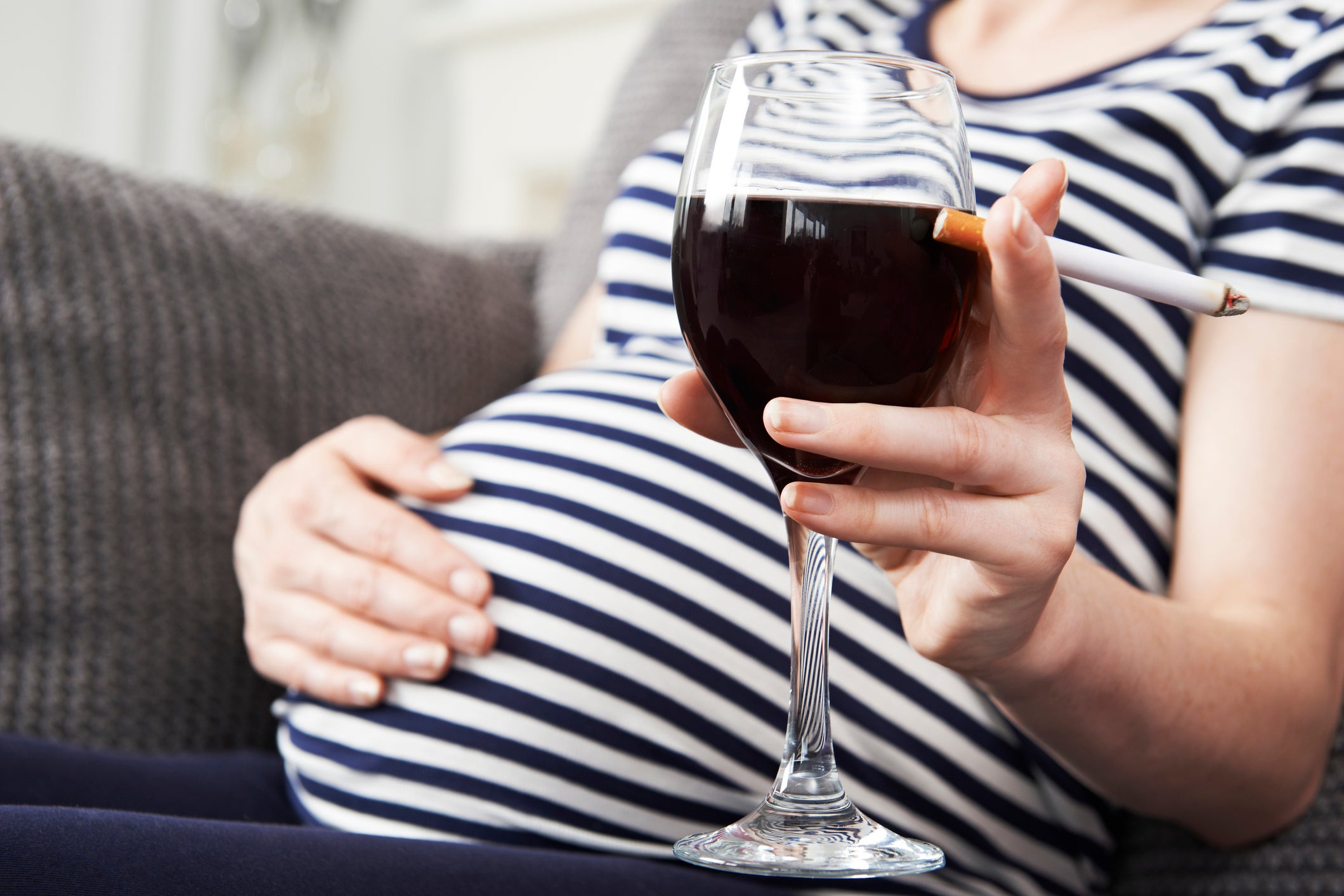 Close Up Of Pregnant Woman Smoking And Drinking