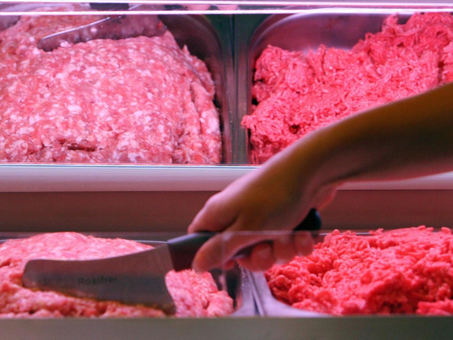 A sales assistant portions mincemeat 01 August 2007 in a butcher's shop in Berlin.