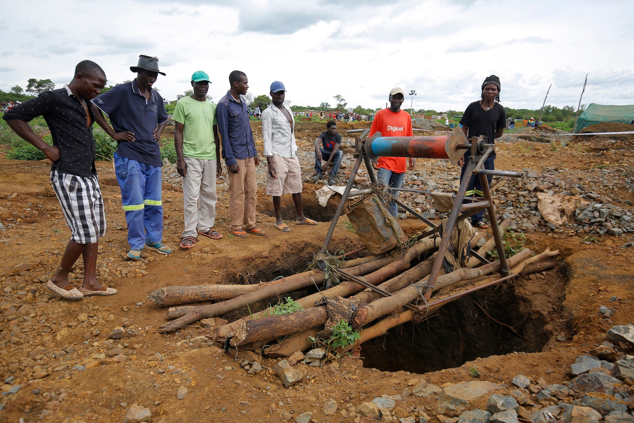 People gather around one of the shafts at Cricket Mine outside Kadoma more than 200 km west of the capital Harare, Zimbabwe, 14 February 2019 where more than 40 artisanal miners died on 12 February 2019.The miners died when the shafts in which they working in were flooded by raining water.Efforts are being made to pump out the water so that the bodies can be retrieved.
