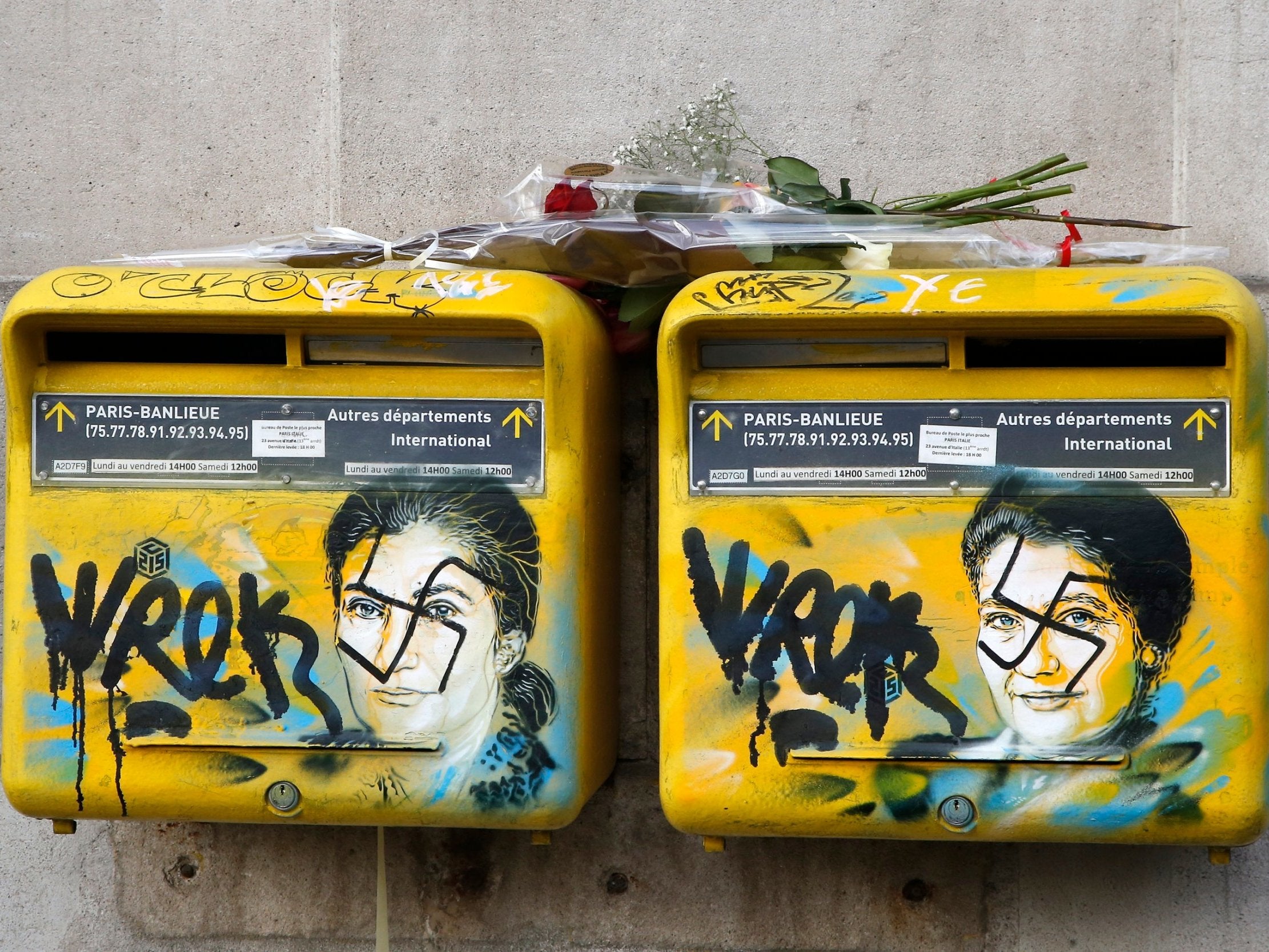 A rose is placed on vandalised post boxes in Paris which have swastikas covering the face of the late Holocaust survivor and renowned French politician Simone Veil.