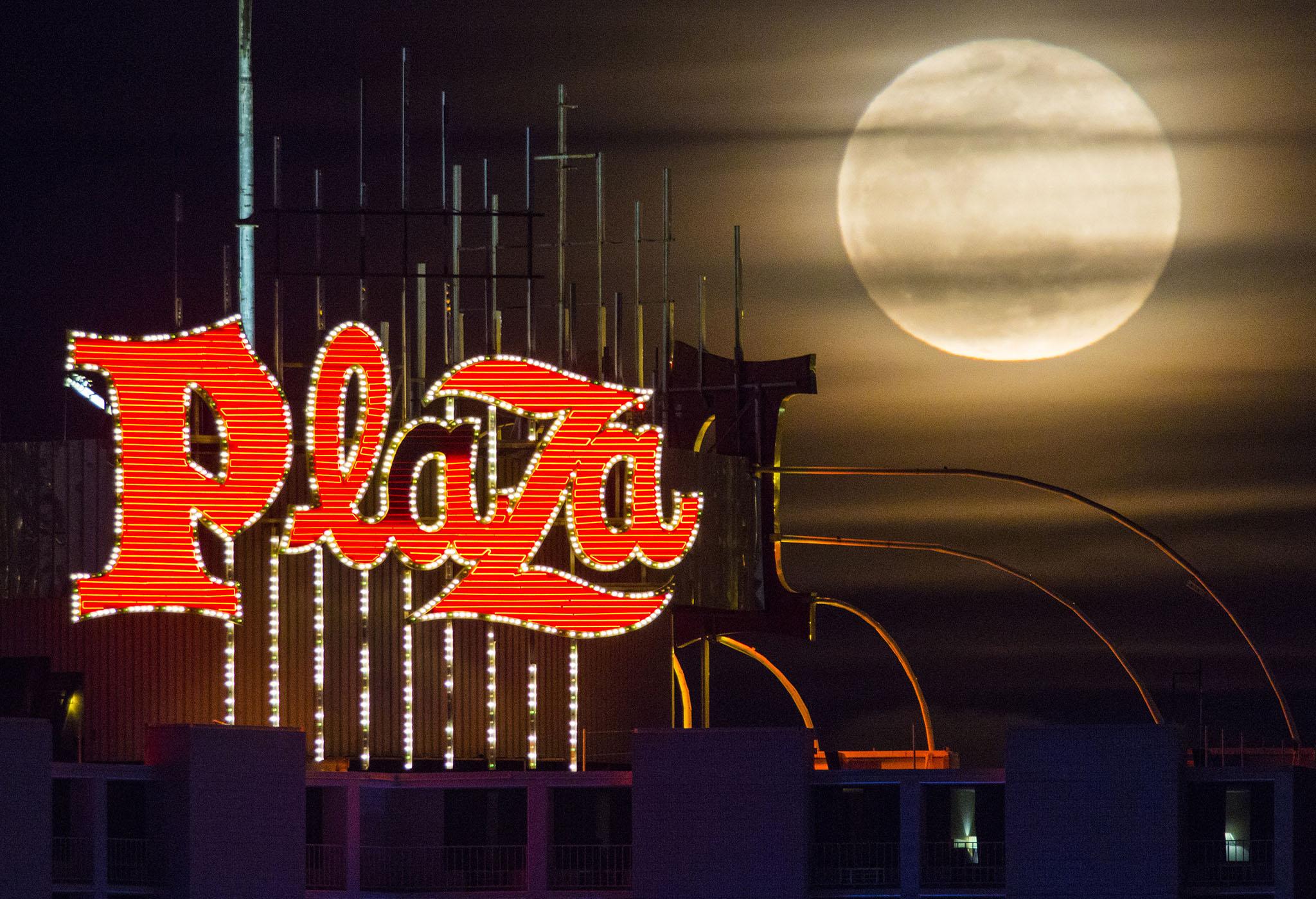 The snow moon rises over the Plaza Hotel and Casino in downtown Las Vegas
