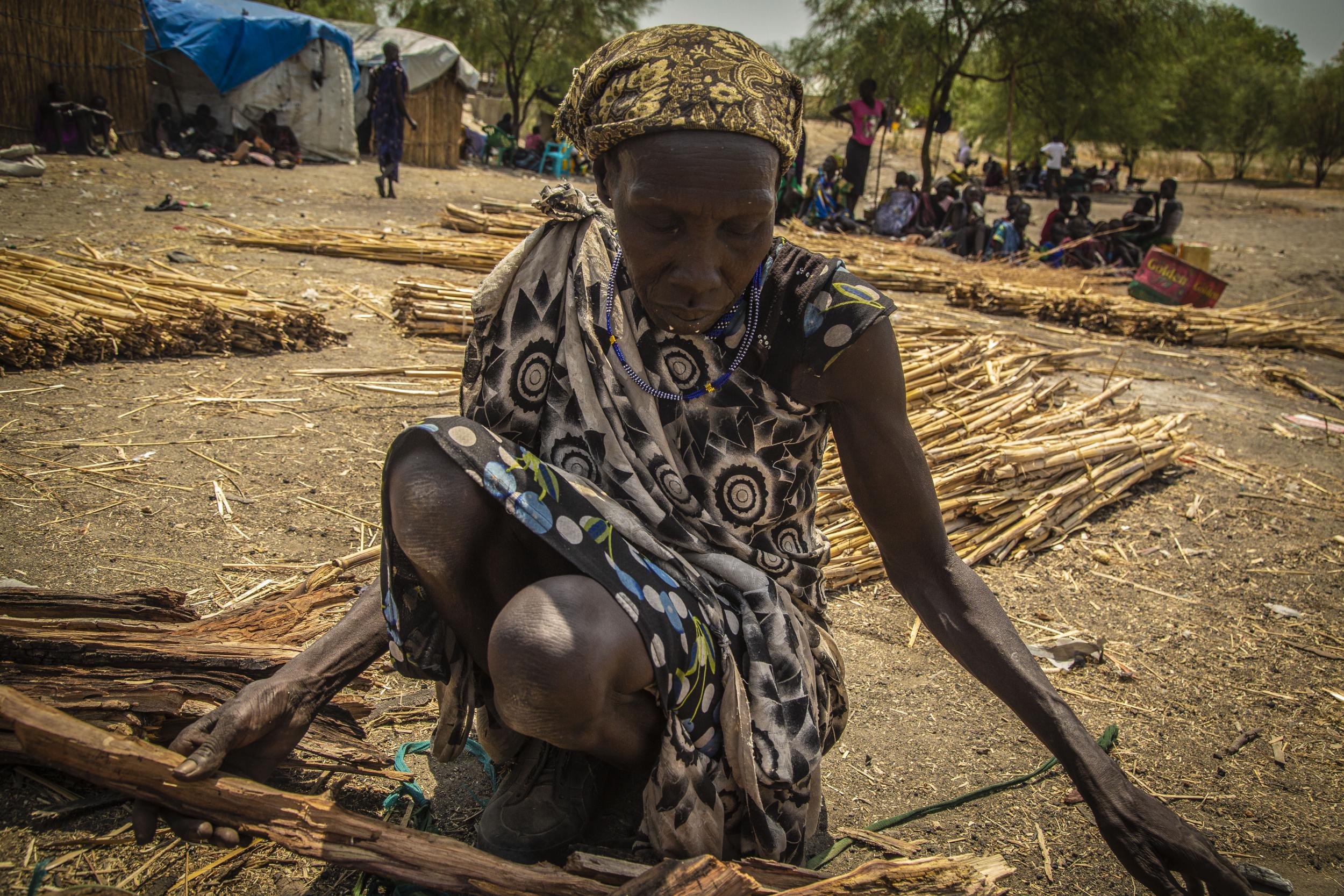 A woman sells firewood in Pibor market, South Sudan. Women risk being assaulted gathering wood