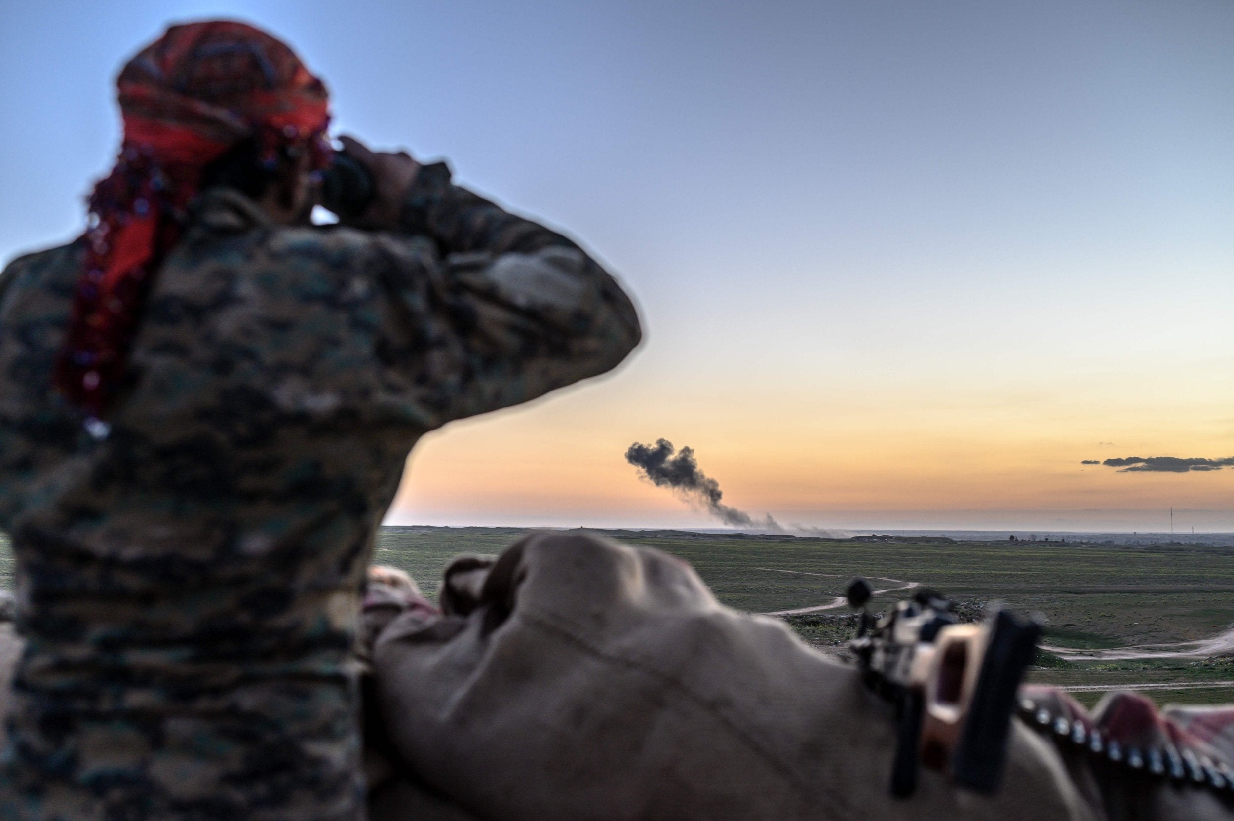 A Syrian Democratic Forces member inspects the embattled village of Baghouz in Deir ez-Zor (AFP/Getty)