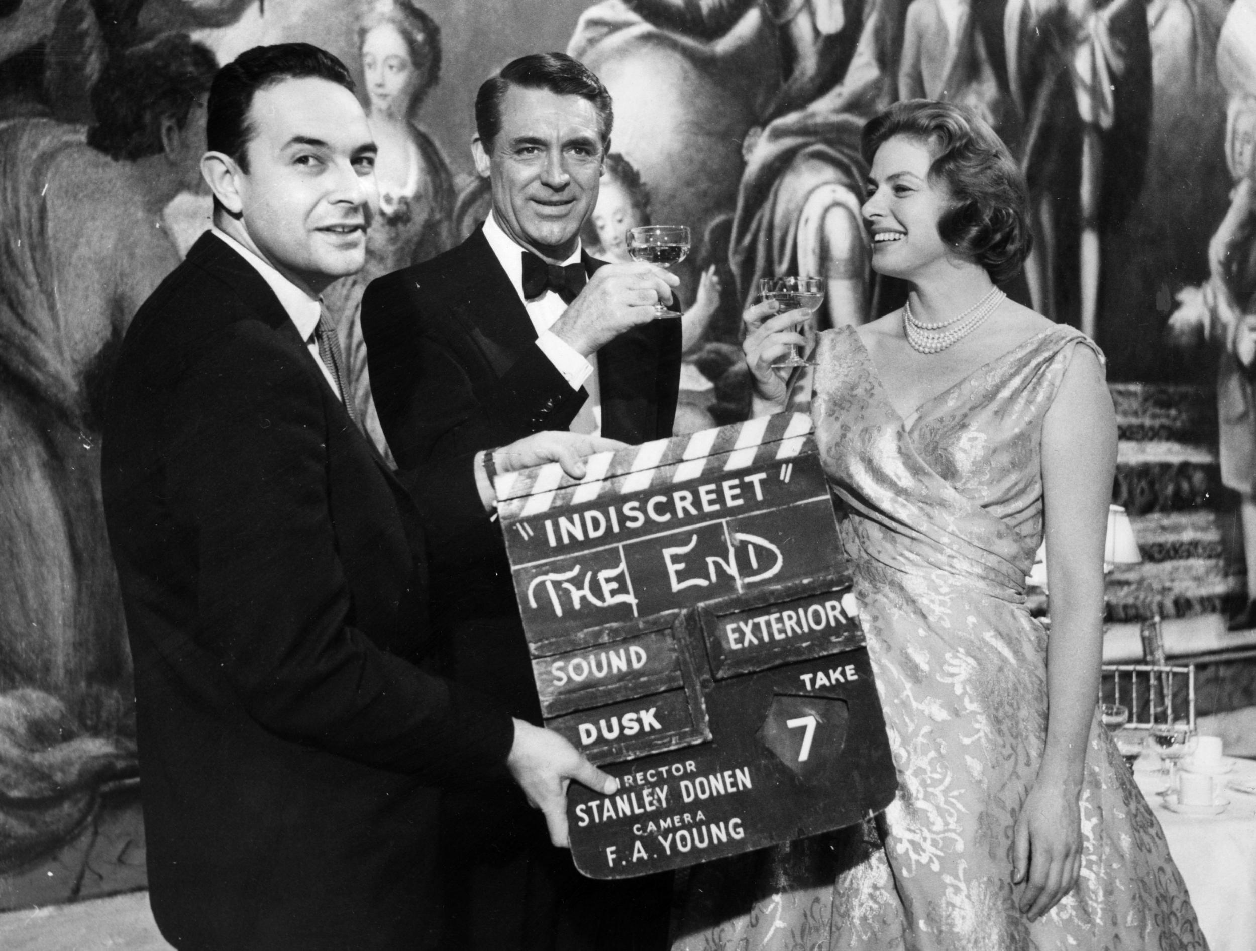 The director holds up the final clapperboard as Cary Grant and Ingrid Bergman celebrate the completion of ‘Indiscreet’ at Elstree Studios (Photo Fox/Getty)