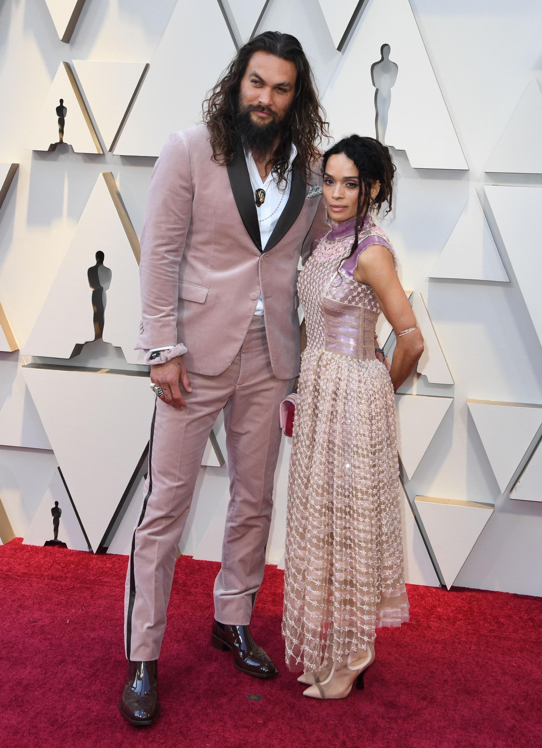 Jason Momoa and Lisa Bonet wear matching pink Karl Lagerfeld-designed outfits to the 2019 Oscars.