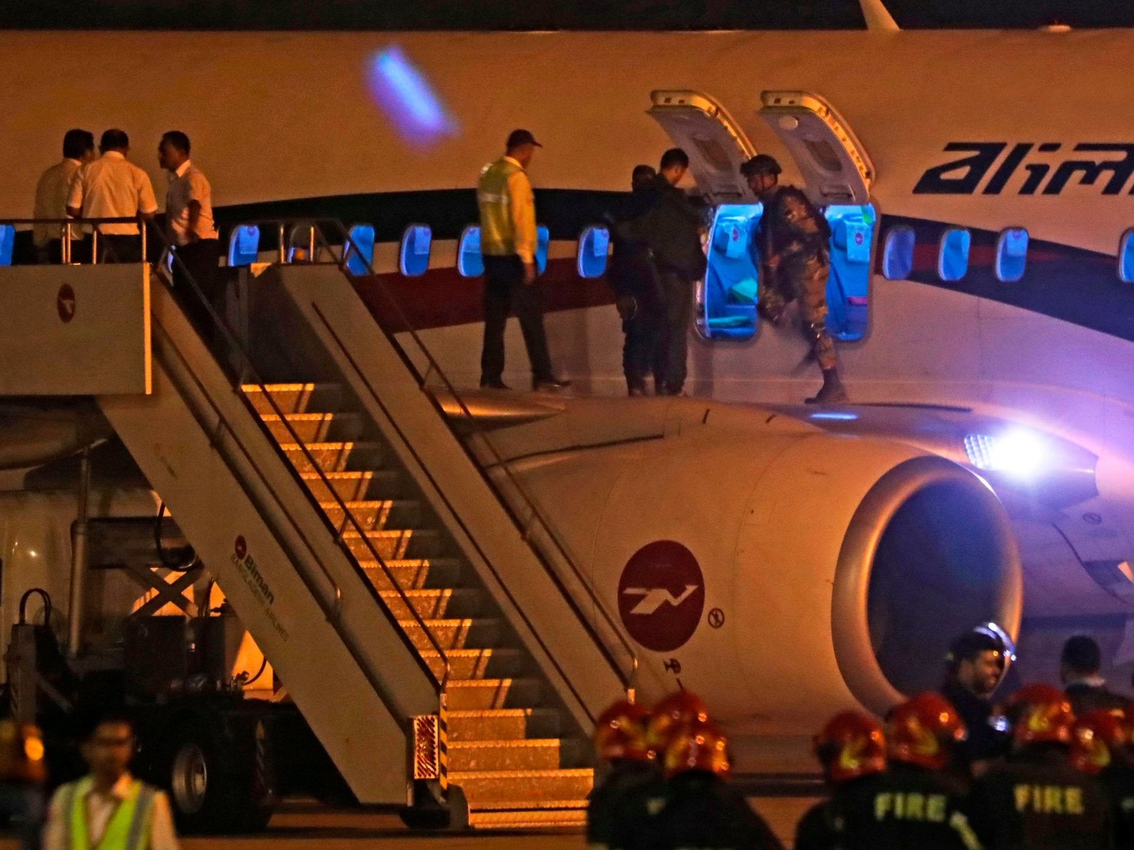 Bangladeshi security personnel inspect plane after exchange of gunfire with hijacker