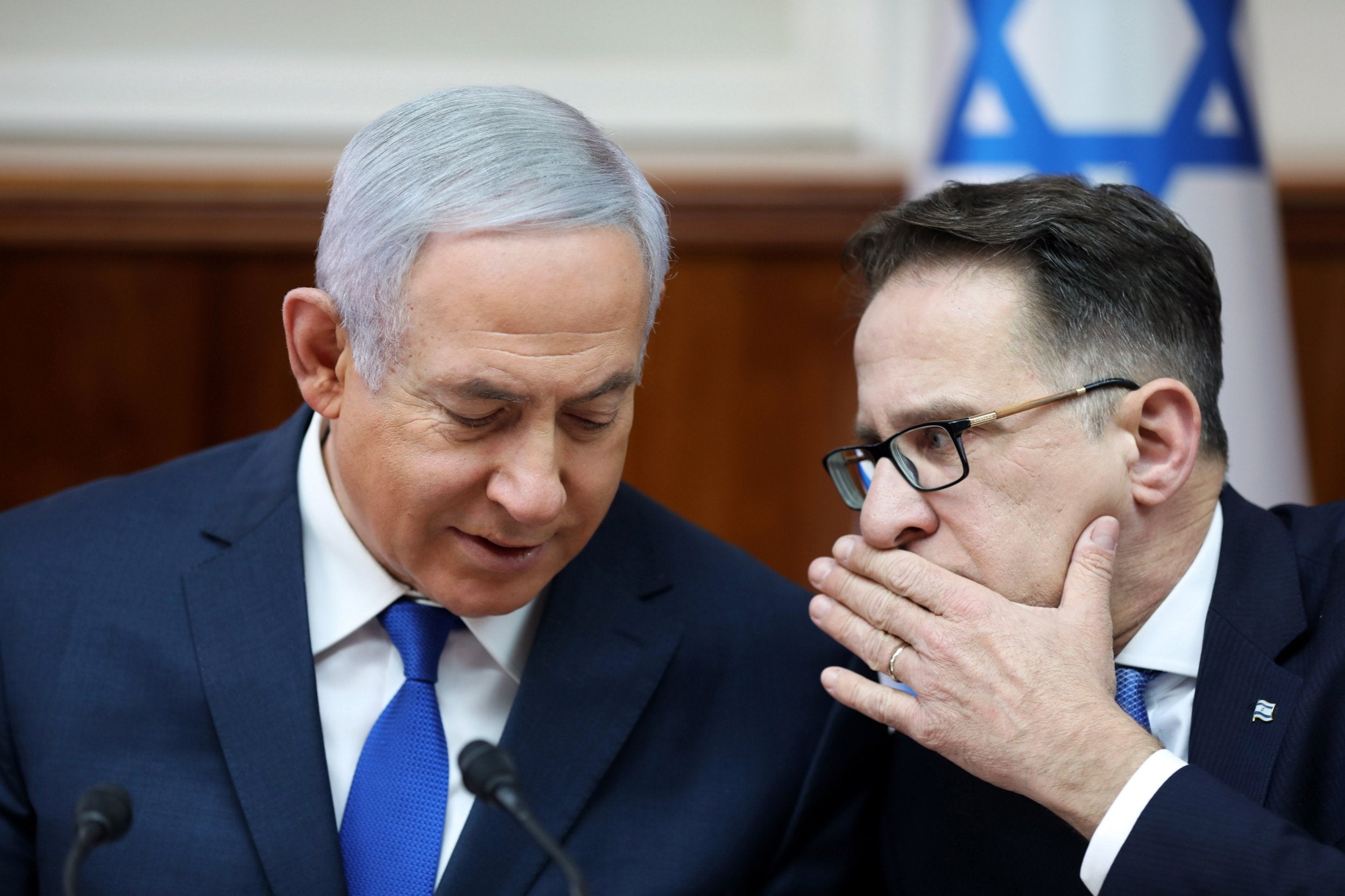 Israeli Prime Minister Benjamin Netanyahu (L) speaks with Government Secretary Tzahi Braverman (R) during the weekly cabinet meeting at his office