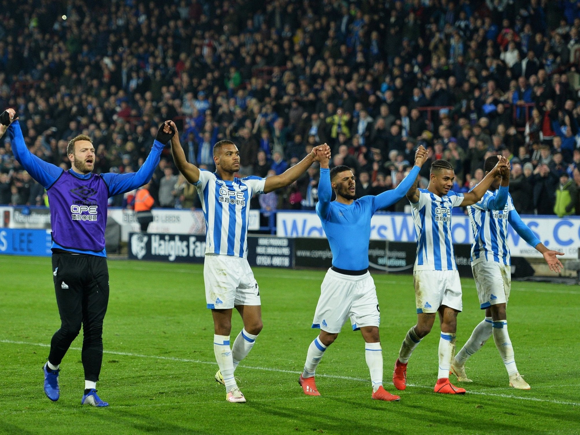 Huddersfield players celebrate with their supporters at full-time