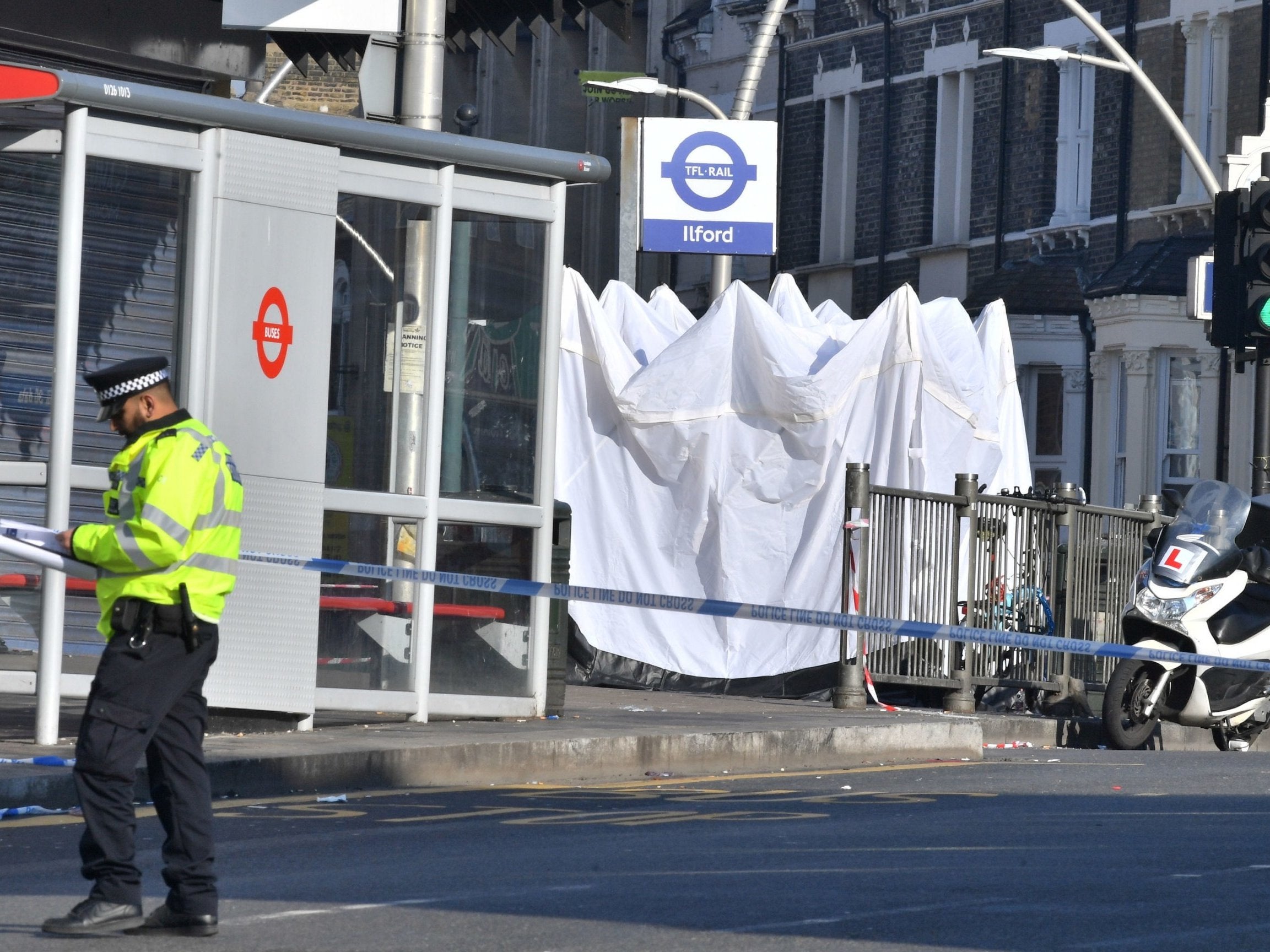 Police at the scene of a stabbing outside Ilford railway station in London where a man