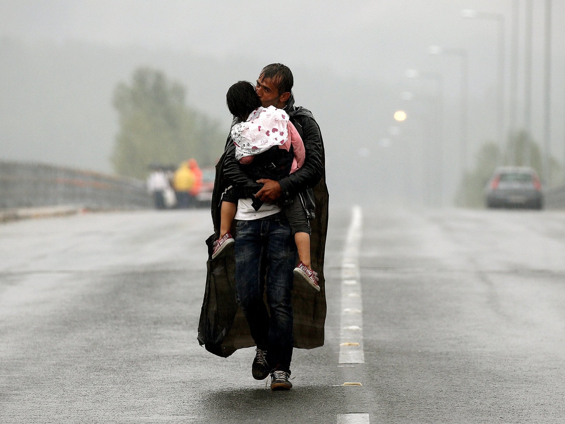 A Syrian refugee kisses his daughter approaching Greece’s border with Macedonia in 2015