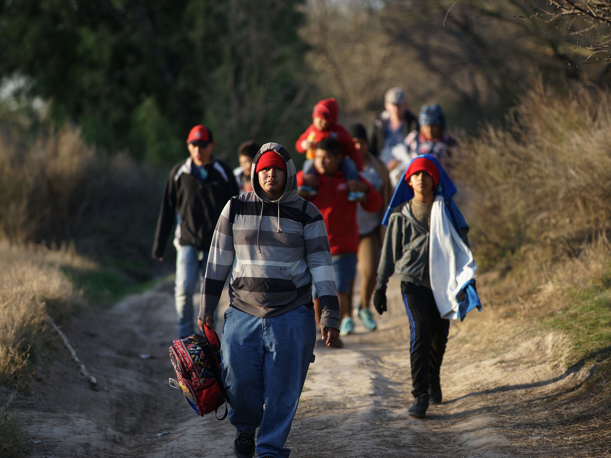 Central American migrants walk along the Mexican bank of the Rio Bravo that divides the cities of Eagle Pass, Texas, and Piedras Negras (AFP/Getty)