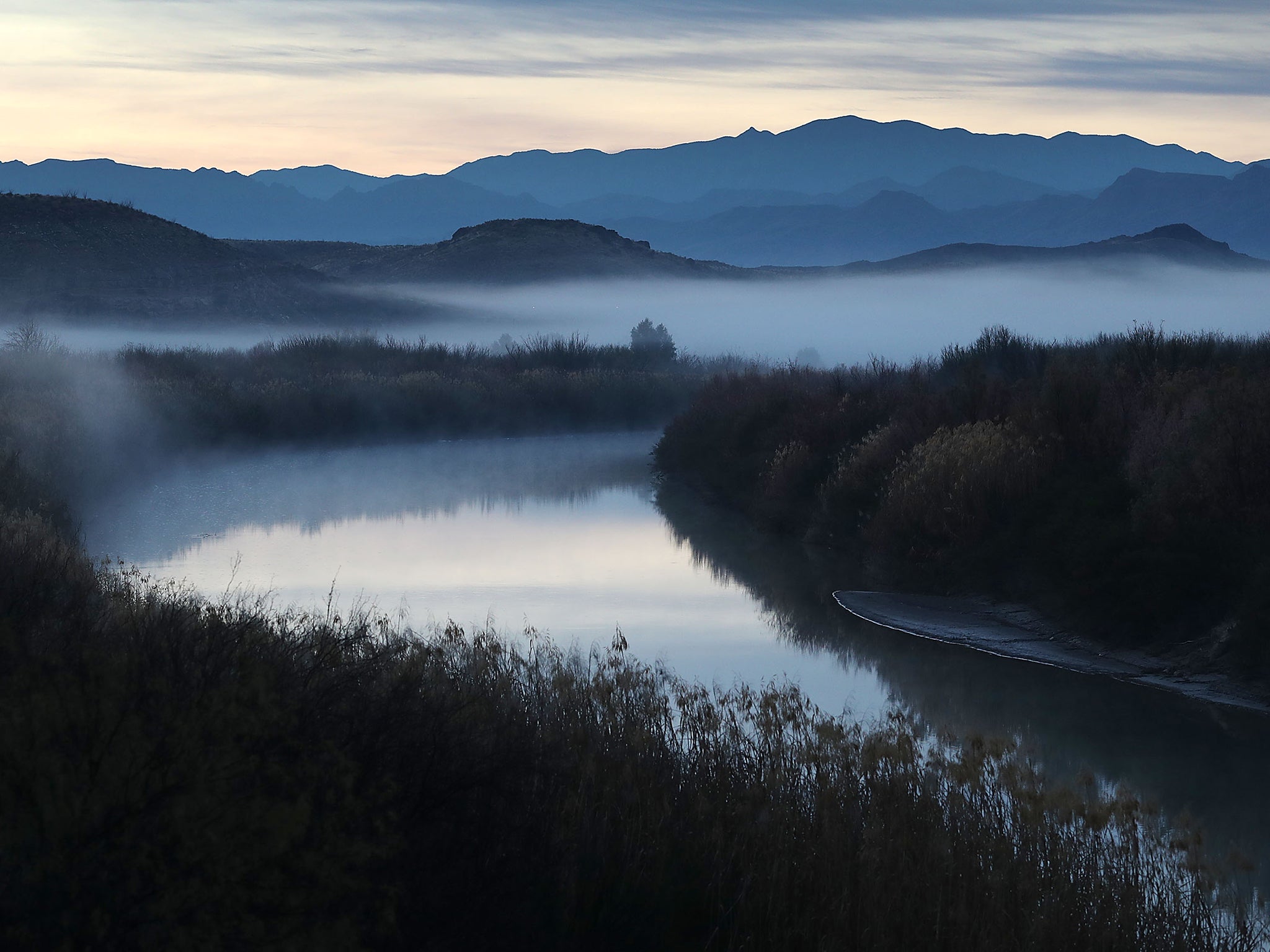 Fog blankets the valley over the Rio Grande which marks the boundary between the US (left of the river) and Mexico