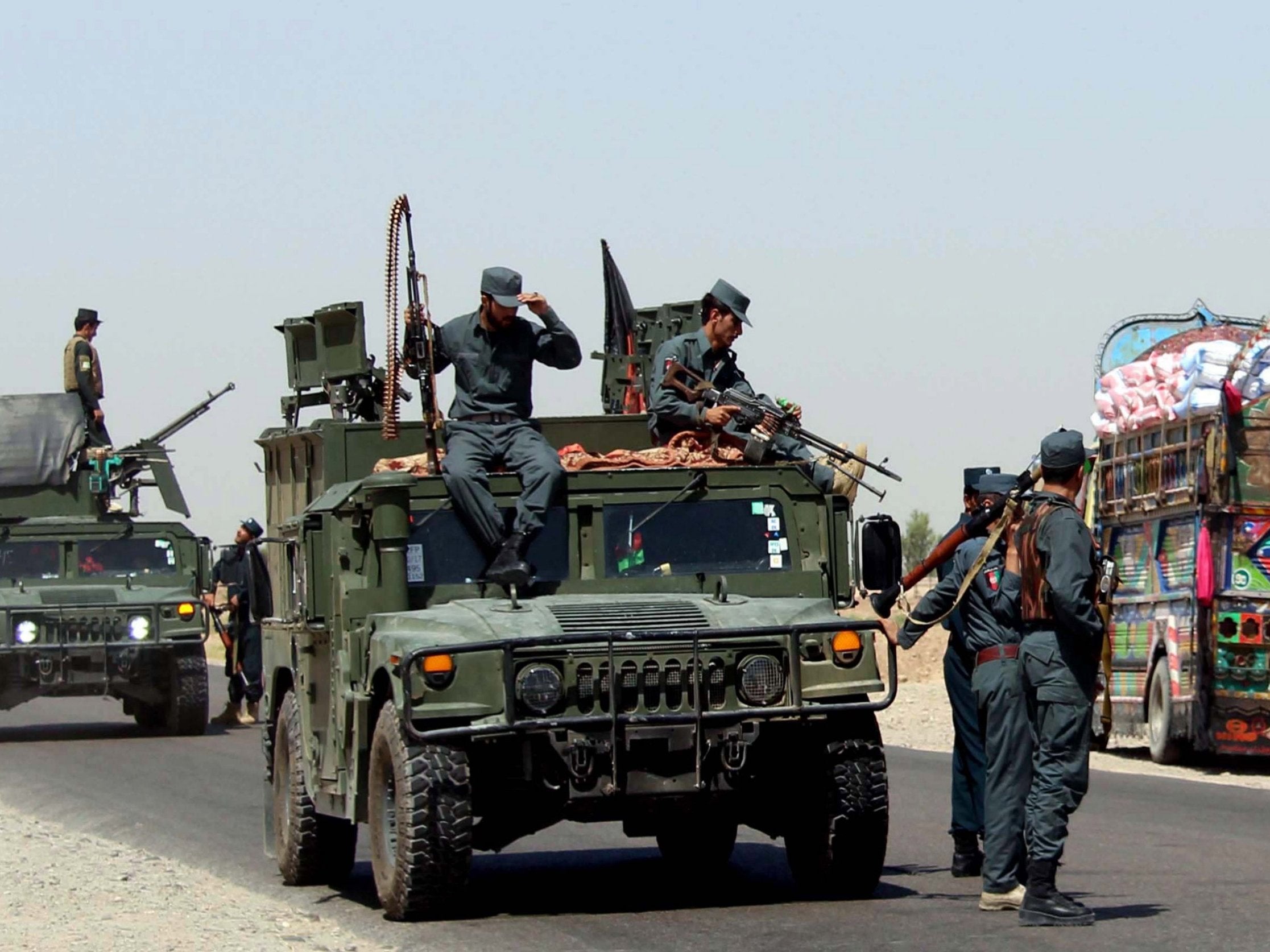 Afghan security officials patrol on the outskirts of Lashkargah, the provincial capital of Helmand, Afghanistan