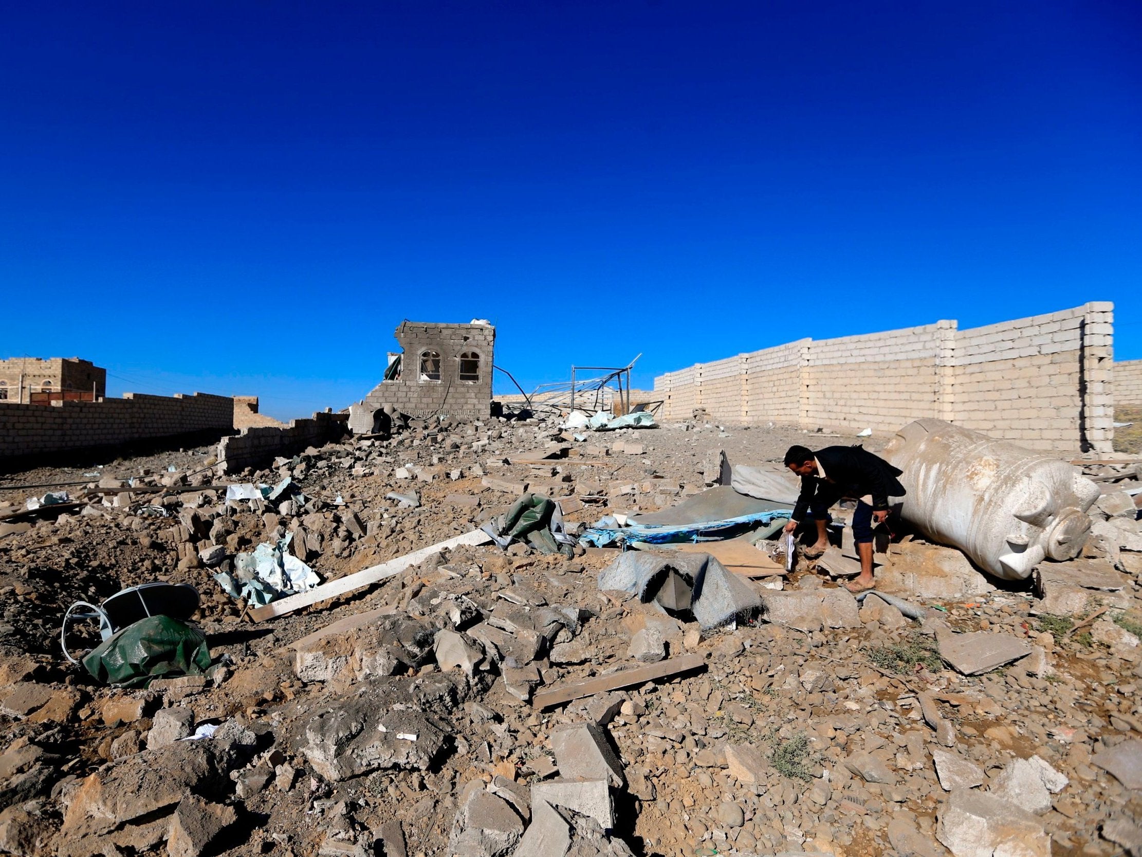 A man checks the debris of a building destroyed in Saudi-led airstrikes in Yemen’s capital