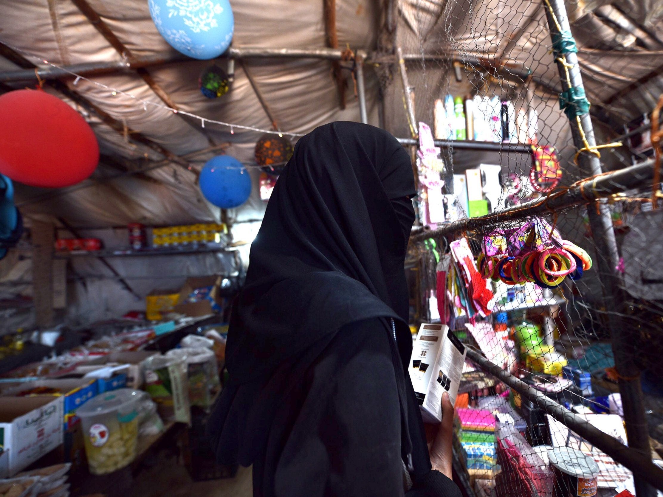 A woman stands at the Roj refugee camp in Hasakah, Syria