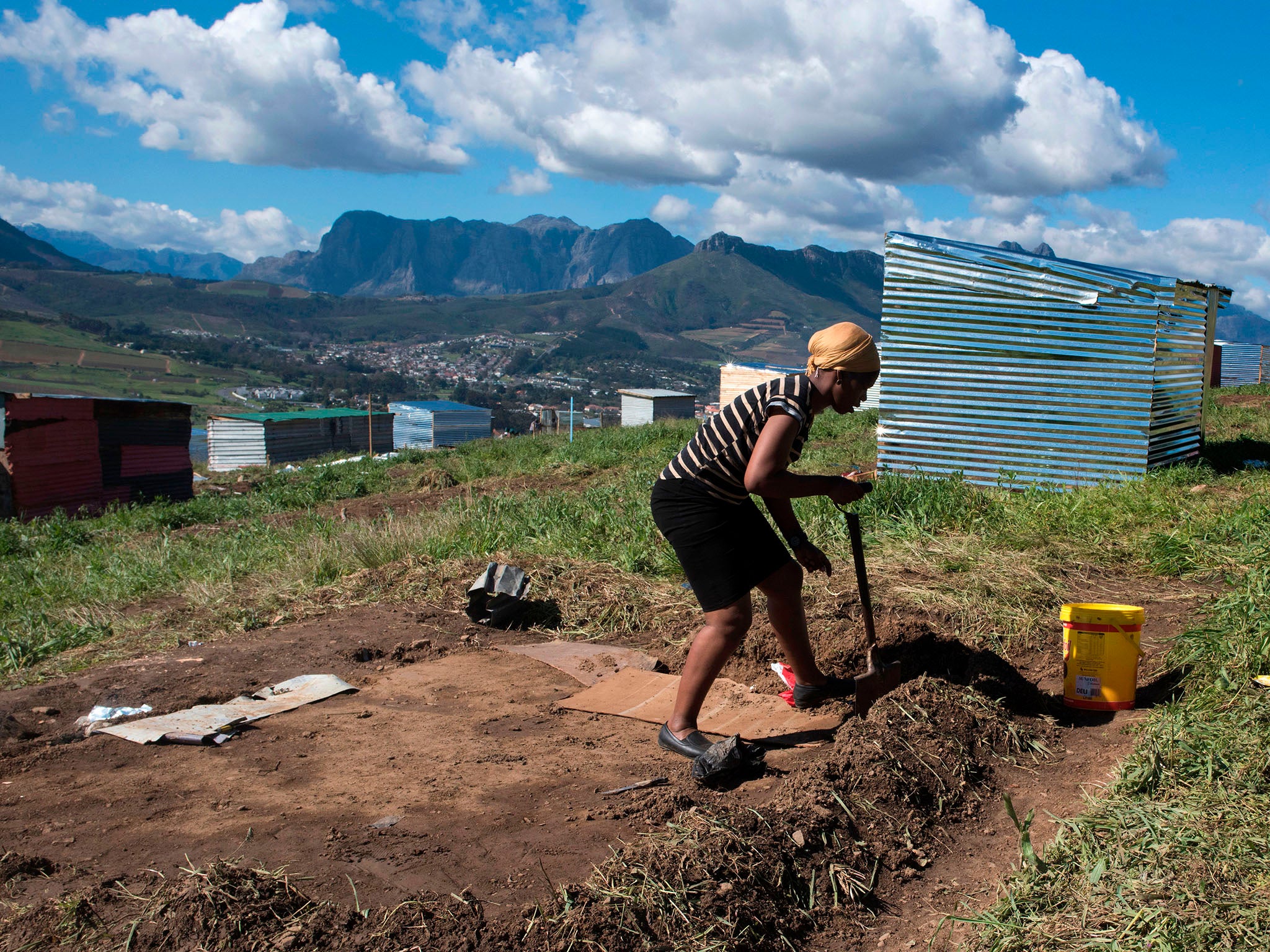 A woman lays out plot on a piece of land belonging to the Louiesenhof Wine Estate on 8 August 2018, in Stellenbosch, which is at the centre of the South African wine-producing region