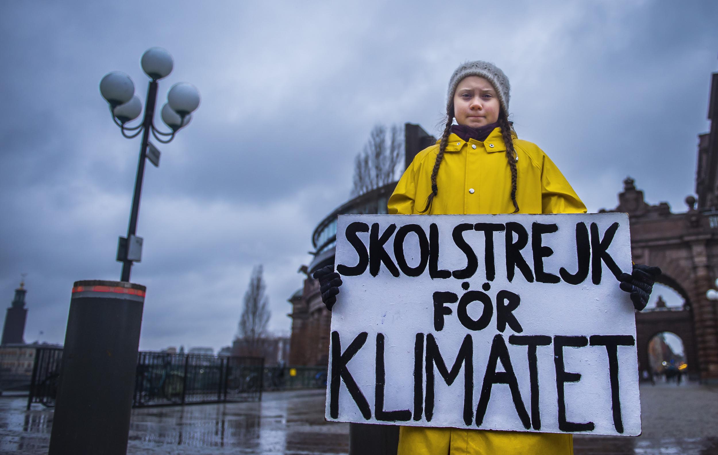 Swedish girl Greta Thunberg holds a placard reading 'School strike for the climate' during a protest against climate change outside the Swedish parliament on 30 November 2018.