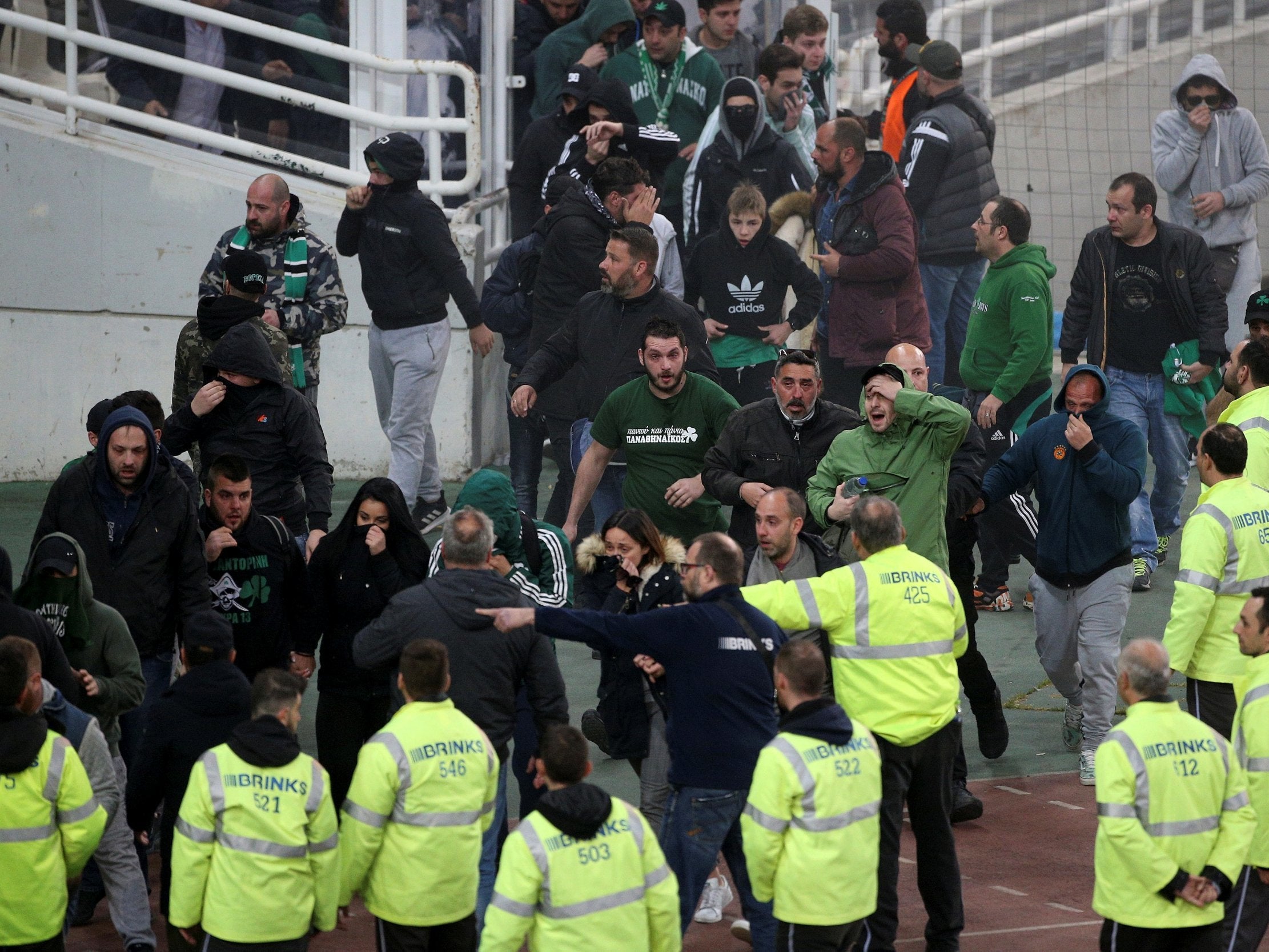 Panathinaikos fans attempt to escape after tear gas is used by the police