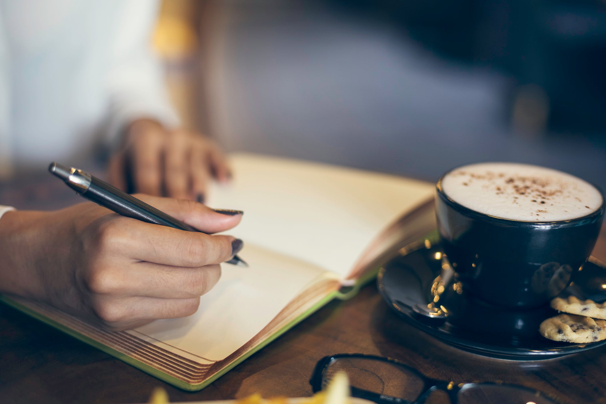 Close up of a woman writing her notebook in a cafe