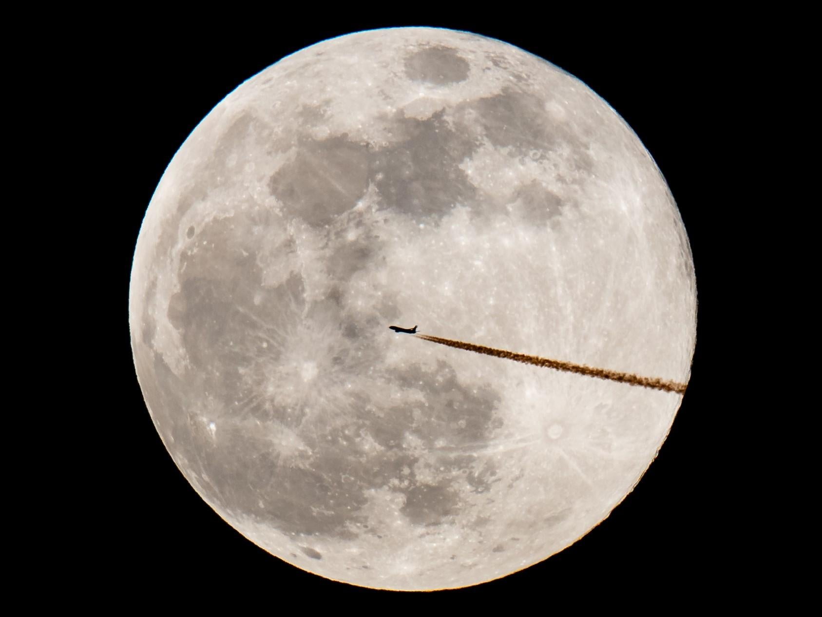 An airplane silhouettes against the supermoon on 19 February, 2019 in Nuremberg, southern Germany