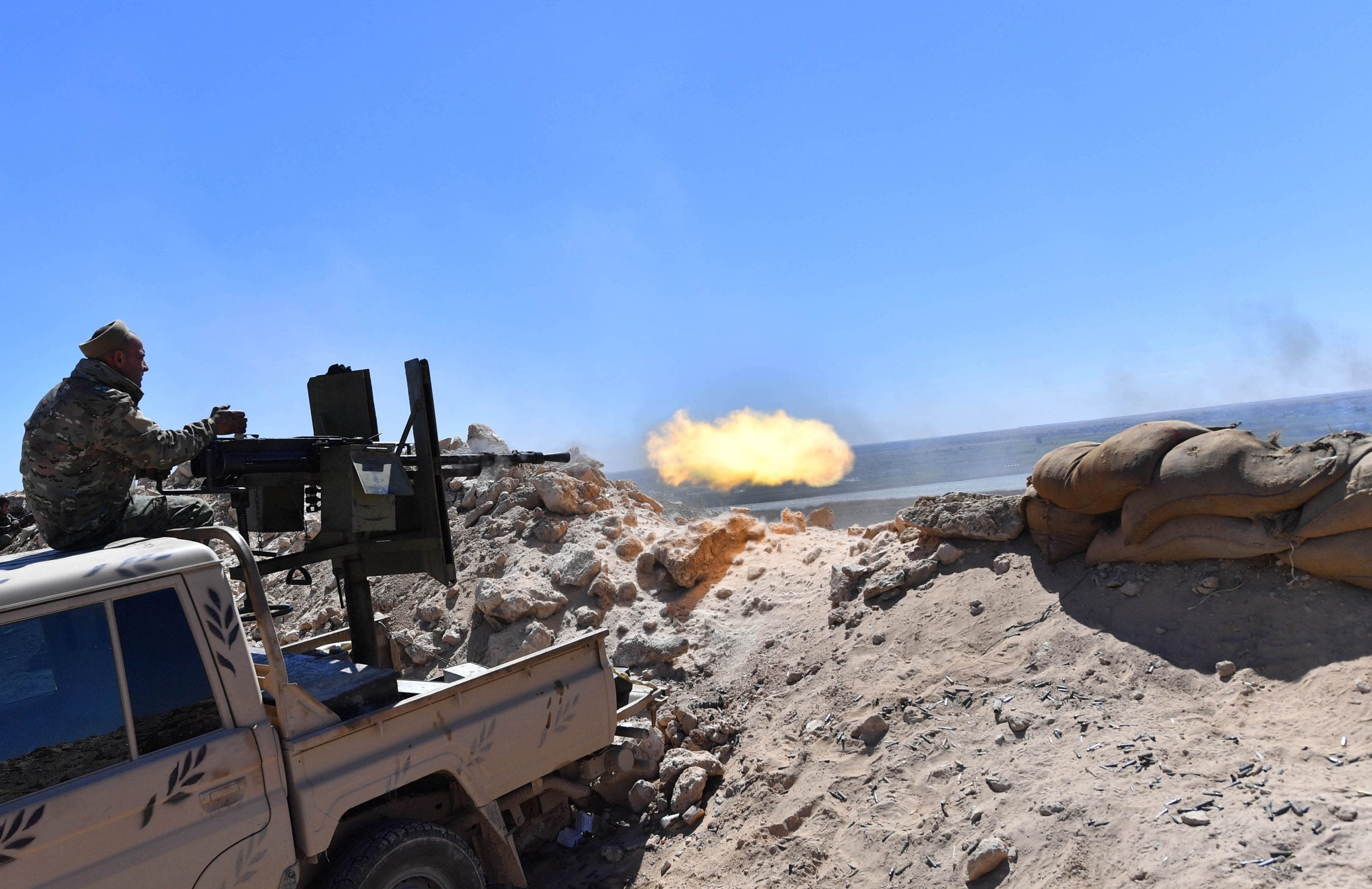 SDF fighters fire a cannon on the frontline of battles in Baghuz