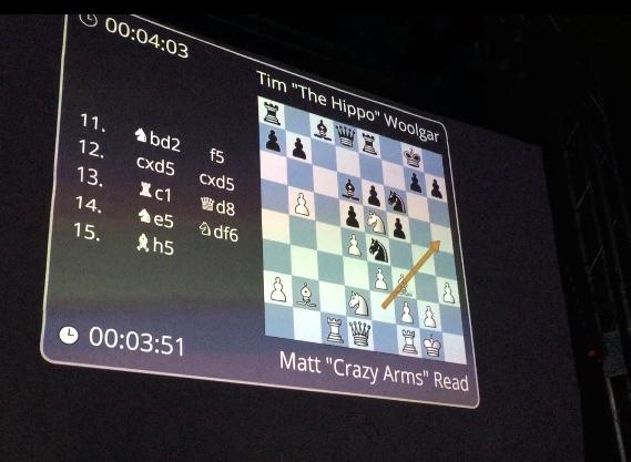 A screen above the ring displays the chess rounds