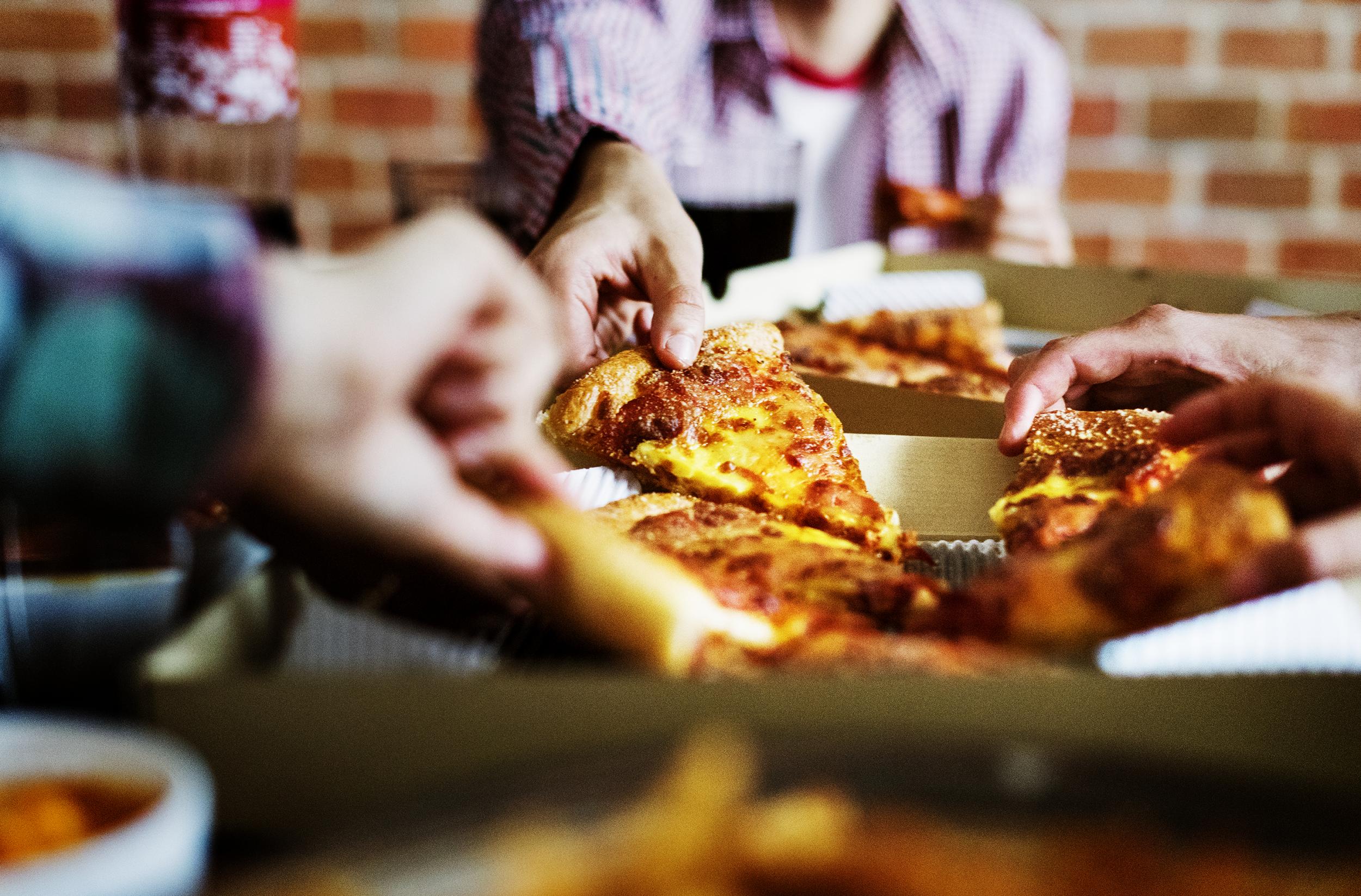 Friends eating pizza together at home