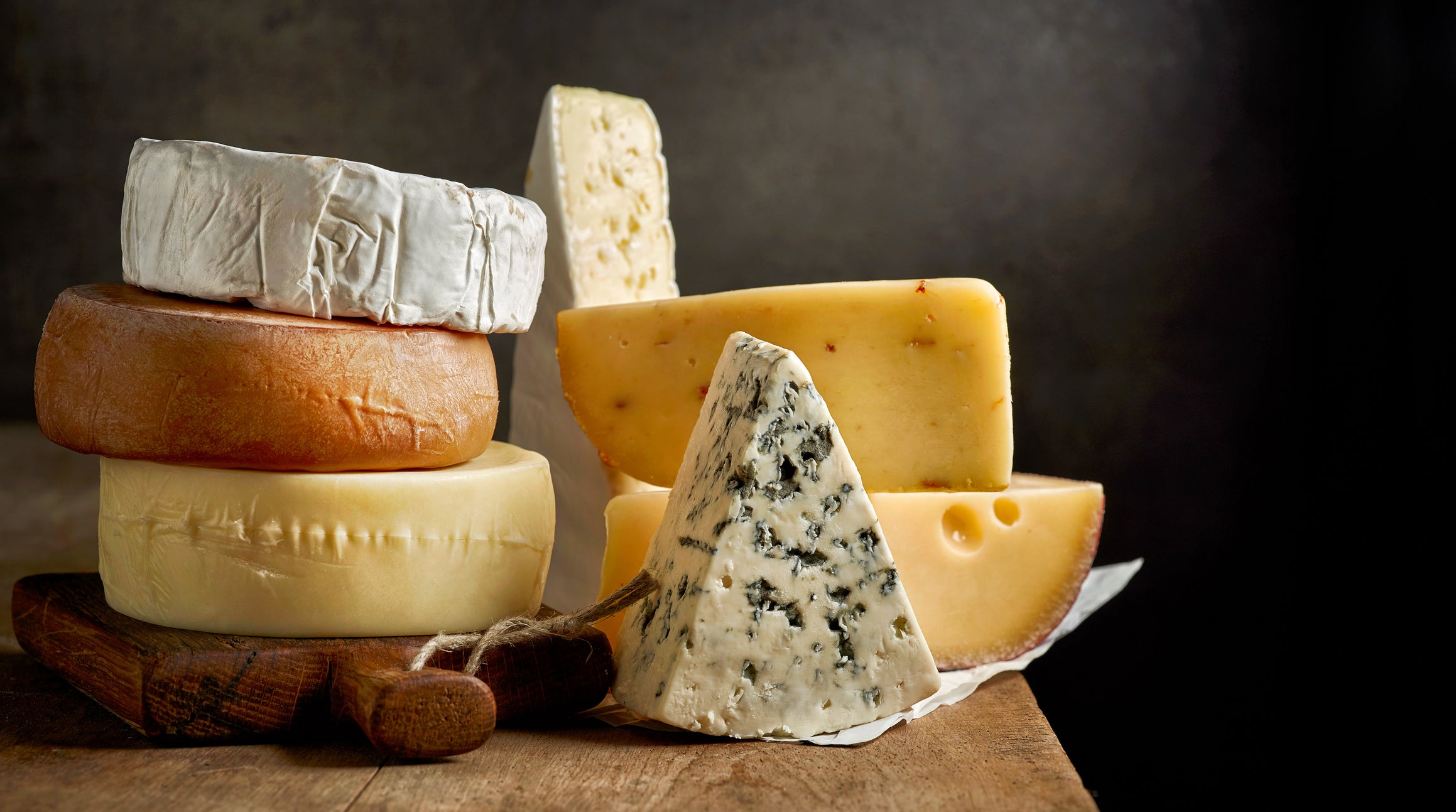 various types of cheese on rustic wooden table