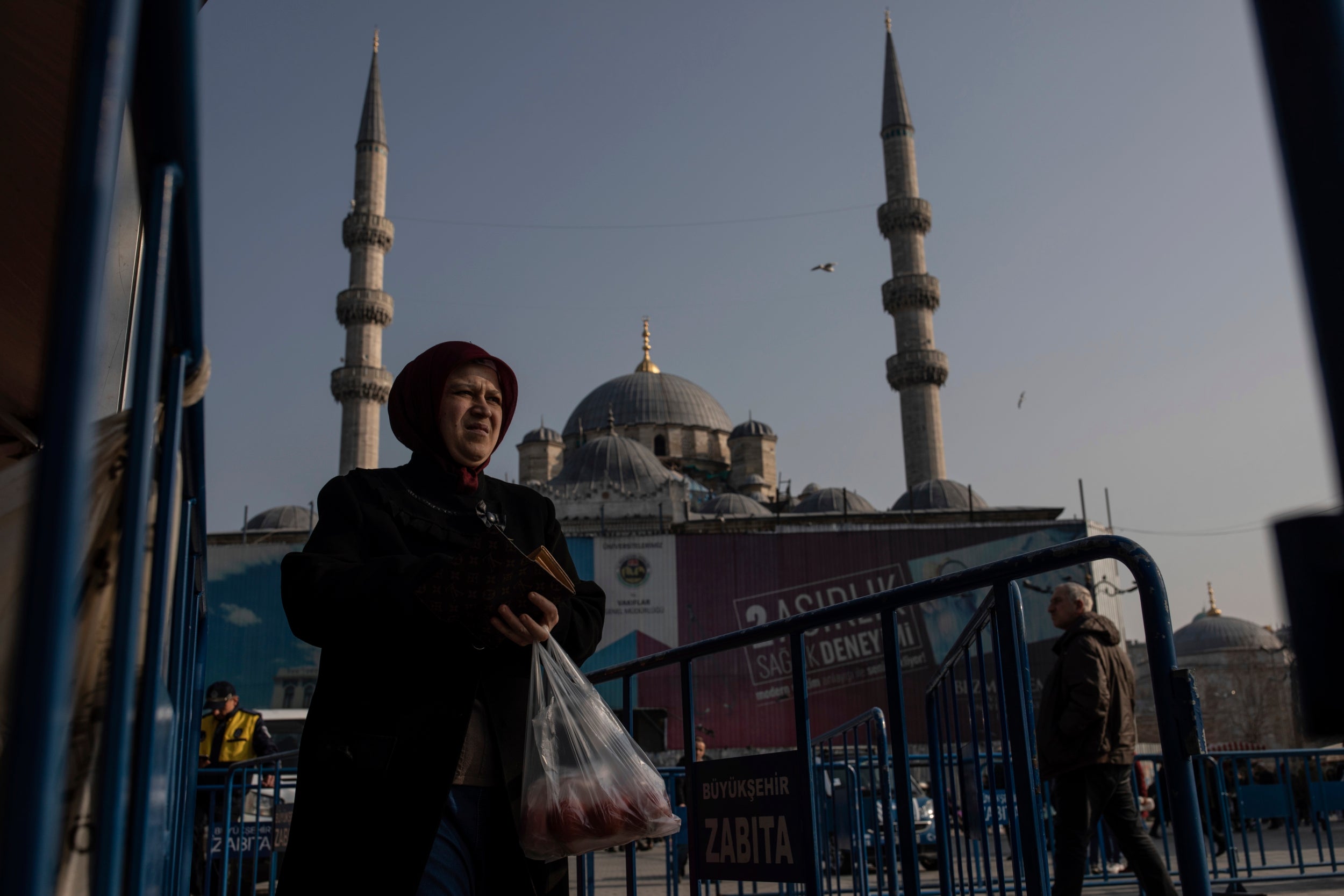 A shopper walks away after buying groceries at a government-run market