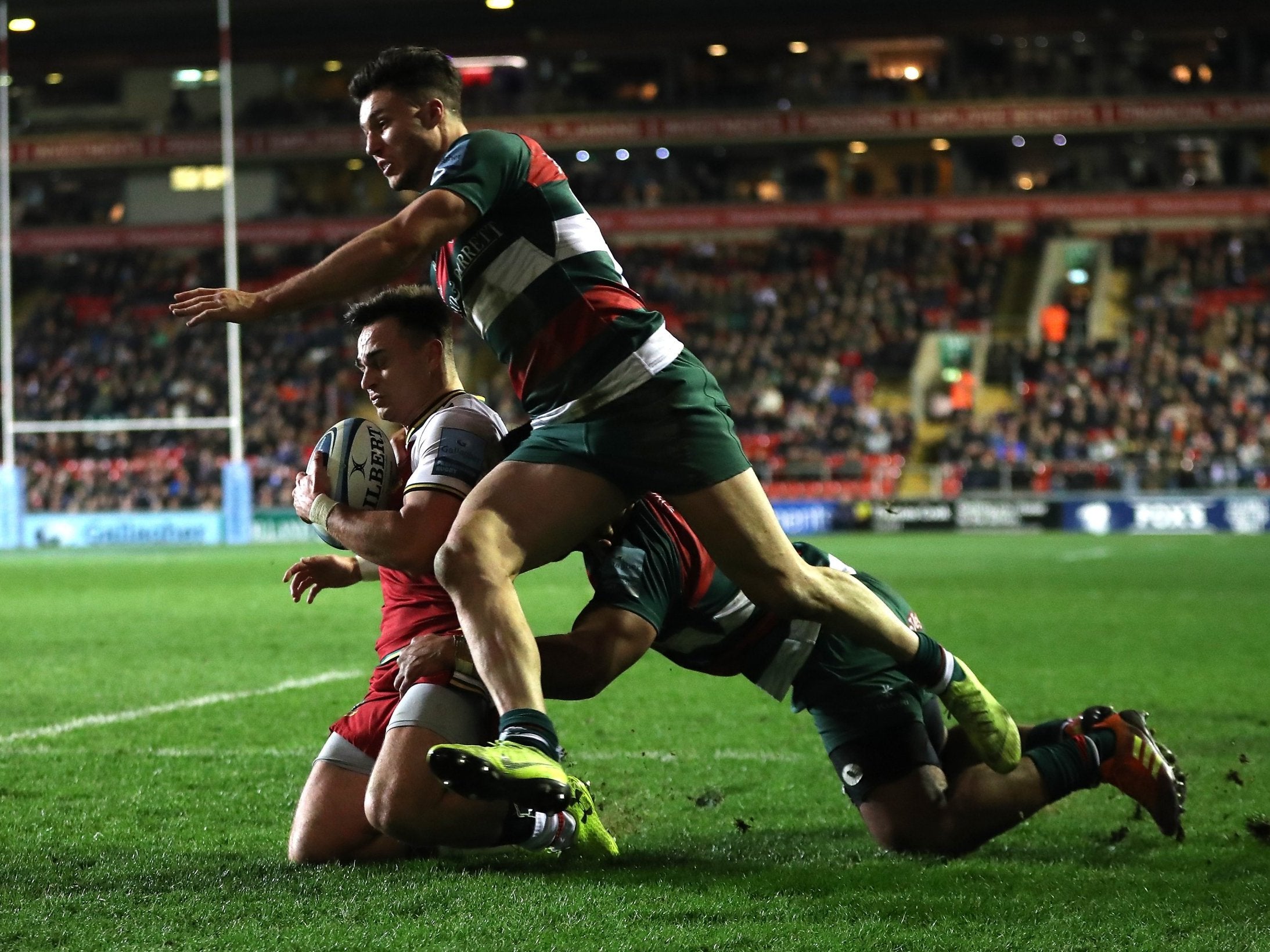 Tom Collins dives over for his second try despite being held by Manu Tuialgi and Sam Aspland-Robinson