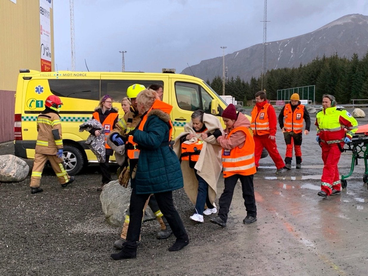 Passengers rescued from cruise ship are helped from a helicopter into Hustadvika rescue centre