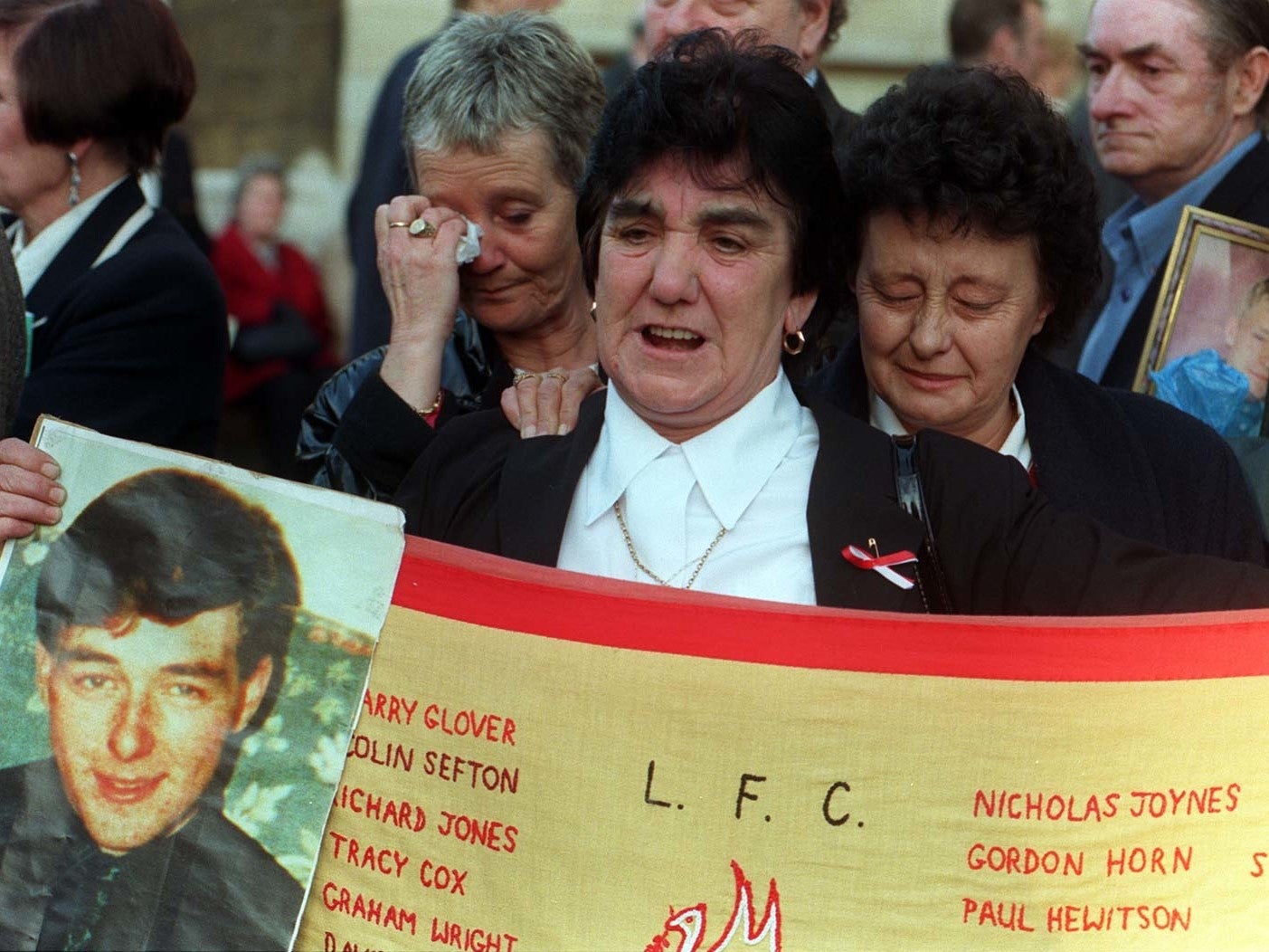 Theresa Glover holds up a photograph of her son, Ian, who died at the age of 20