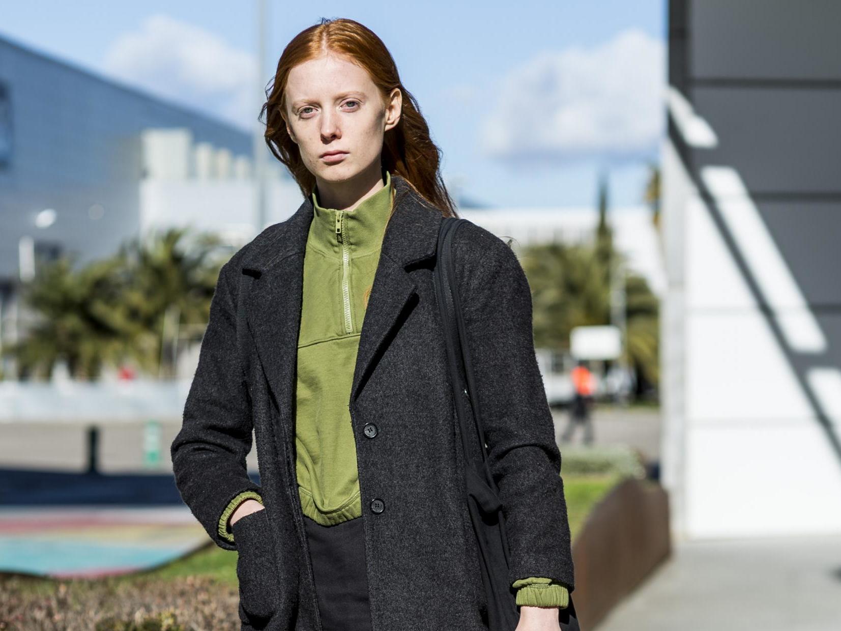 An attendee of Mercedes Benz Fashion Week wears a Weekday shirt and skirt