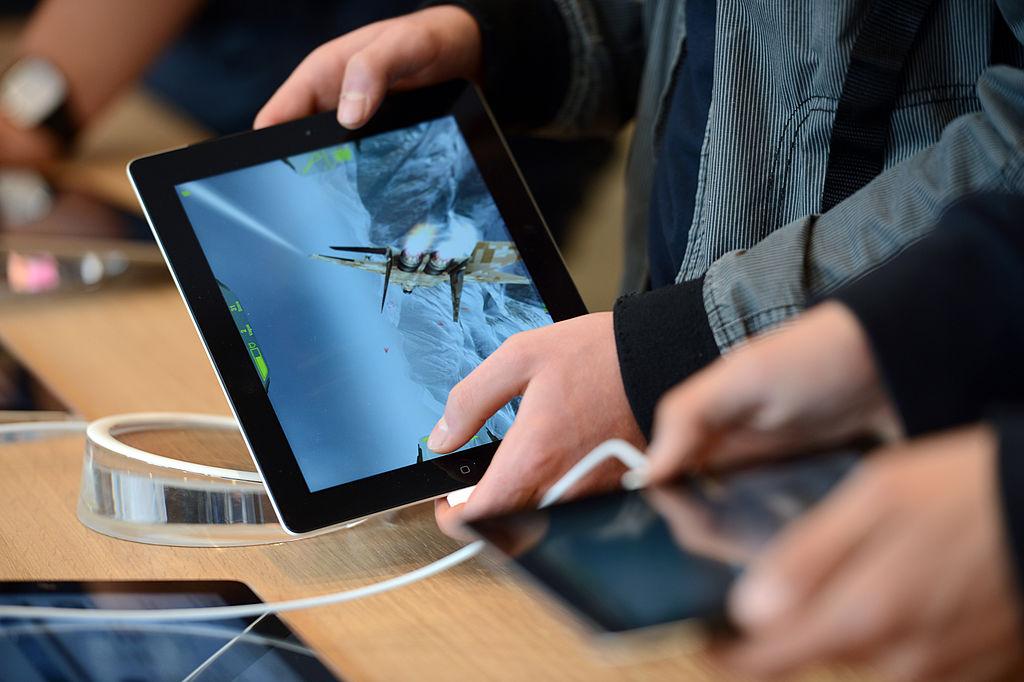 A customer plays with a video game on an iPad during the inauguration of a new Apple store in Strasbourg, France