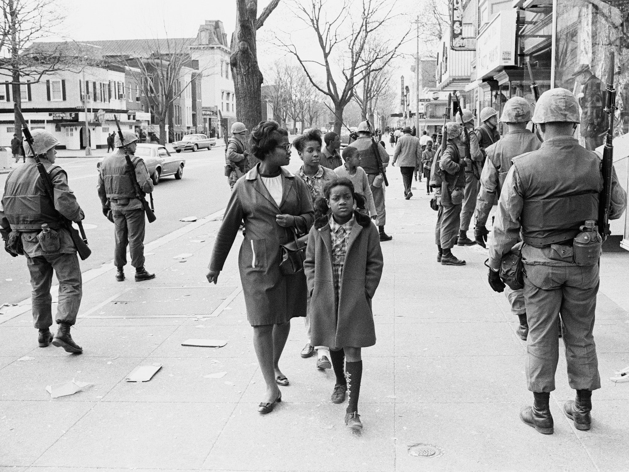 A mother and daughter walk among riot soldiers in Washington DC after the assassination of Martin Luther King Jr