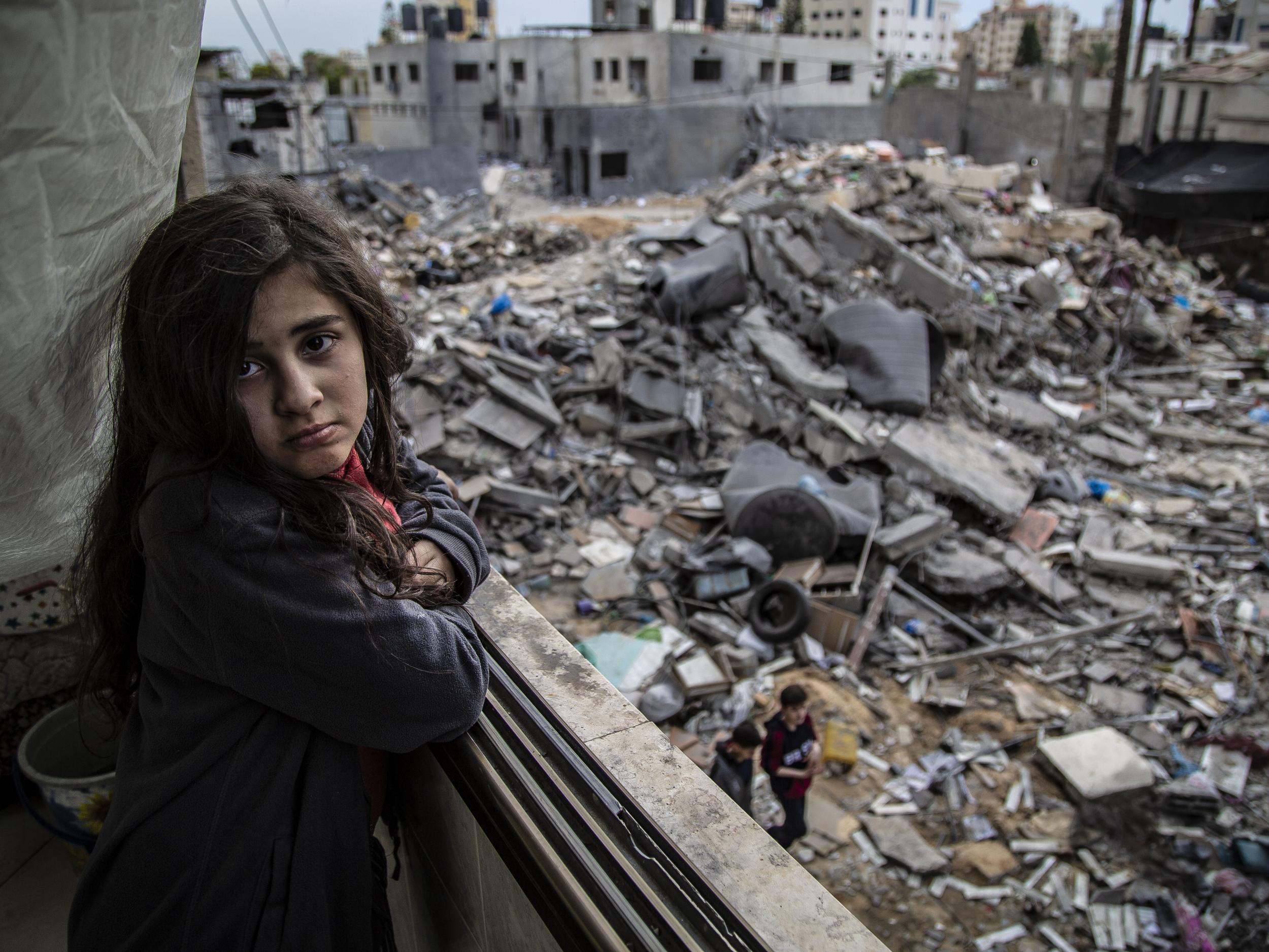 Walid’s niece Nour, 9, looks out at the destroyed remnants of her home after the latest bombings